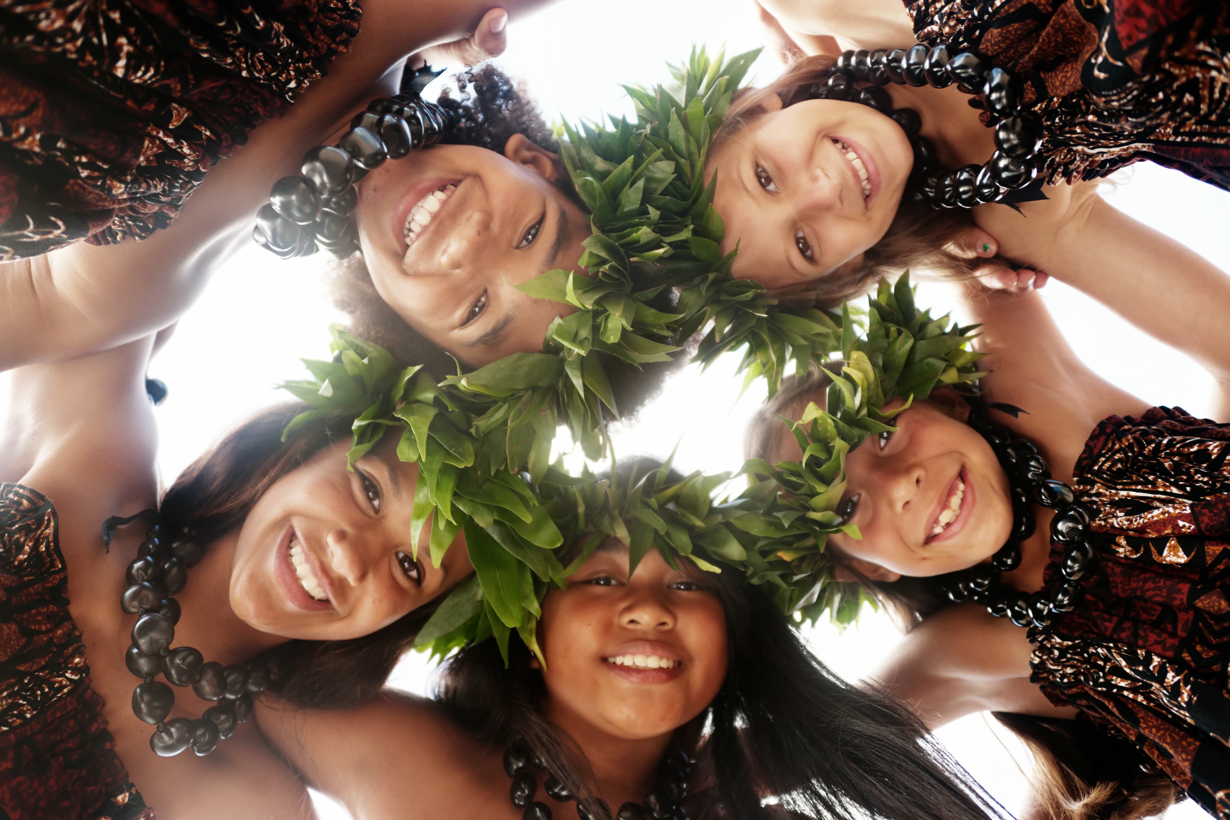 A group of young hula dancers in a circle.