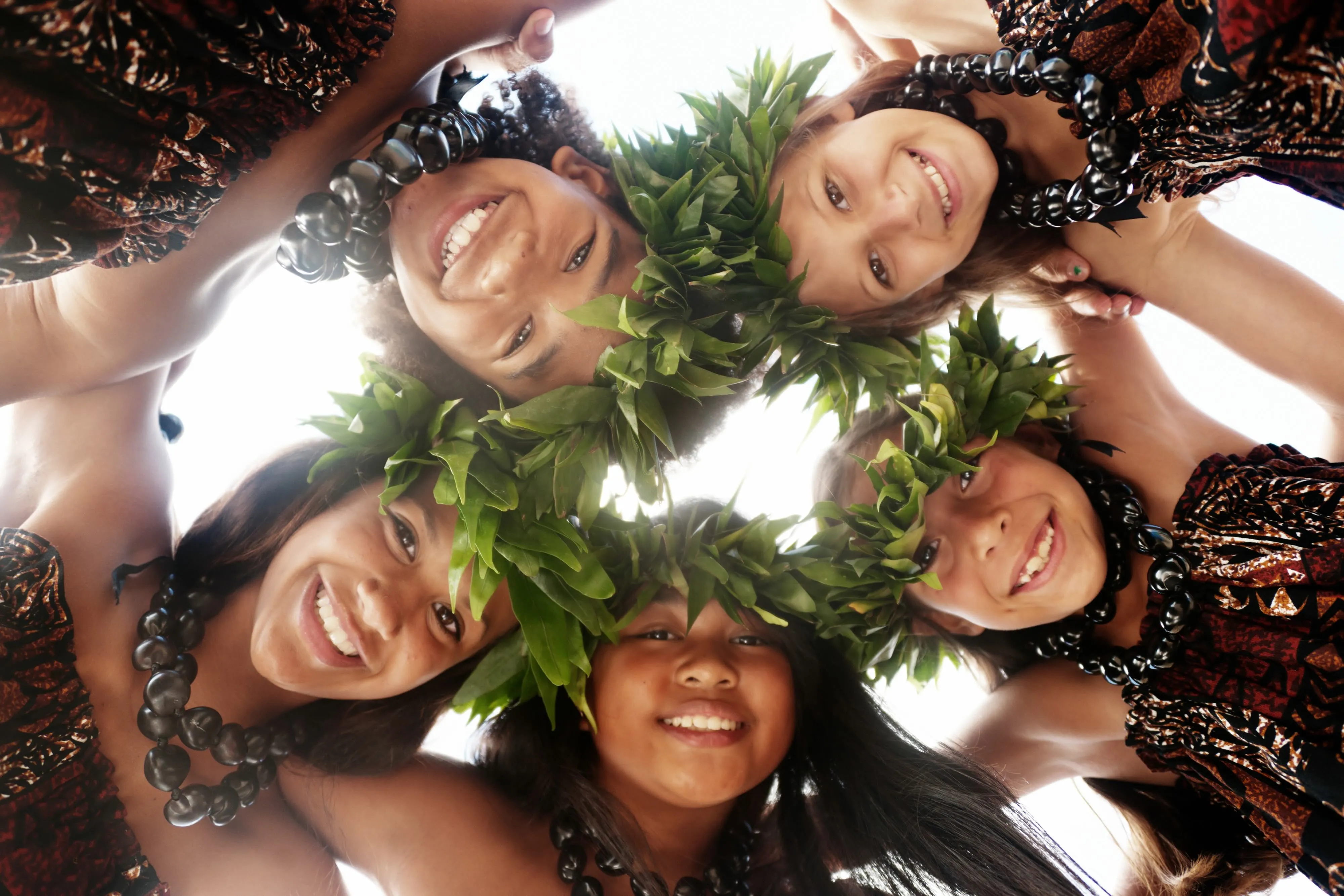 A group of young hula dancers in a circle.