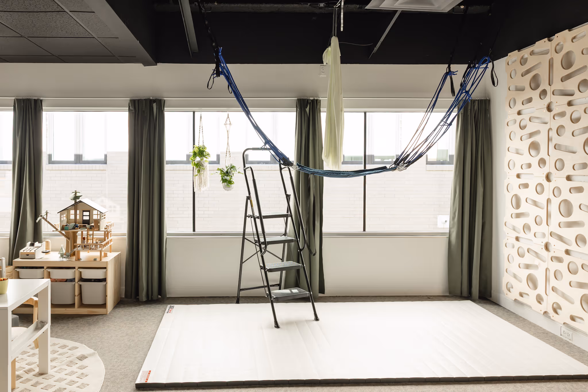 Child therapist setting up sensory swing and bungee jump in the play therapy room Birmingham MI