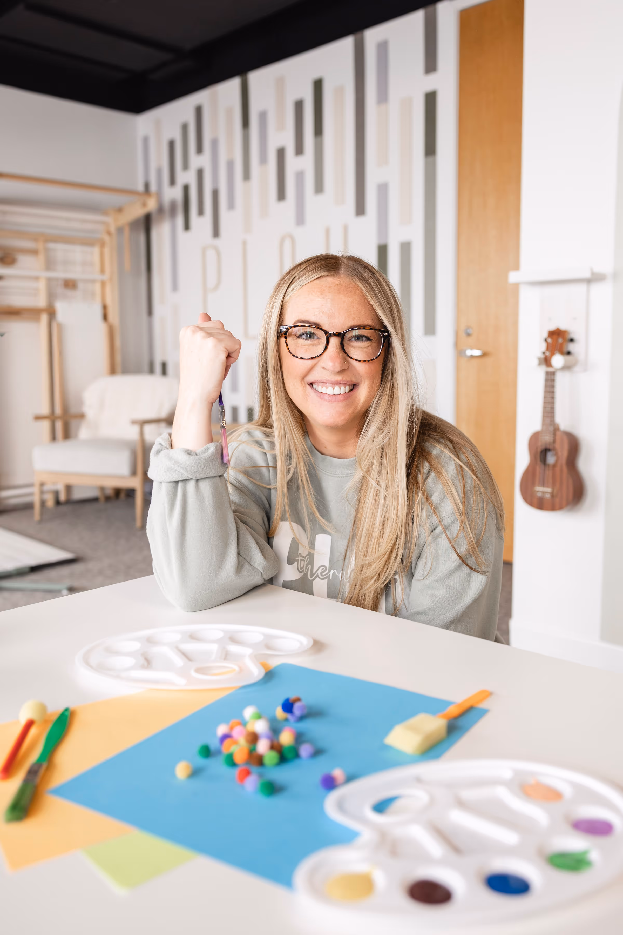 Child therapist holding coffee in front of therapy books at Playful Pathways
Birmingham MI