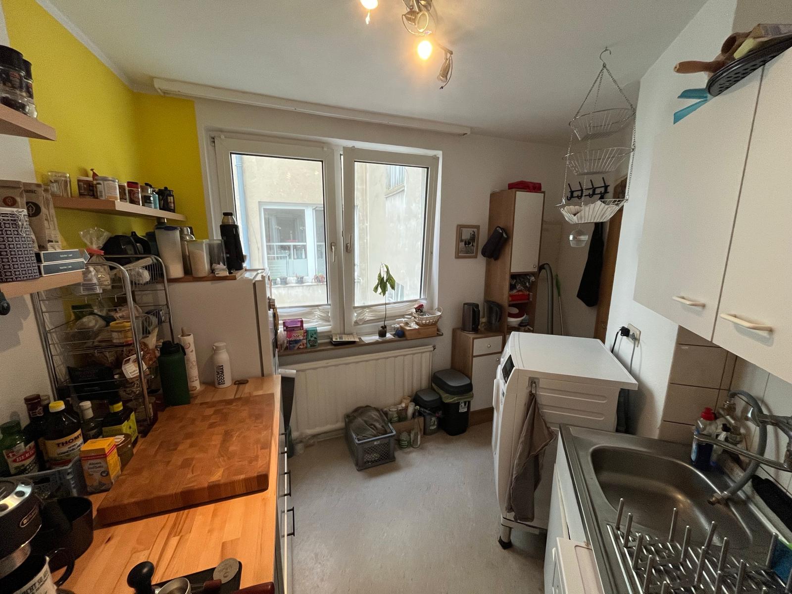 Küche mit Fenster, Arbeitsplatte aus Holz und Waschmaschine in der Wohnung in Aachen