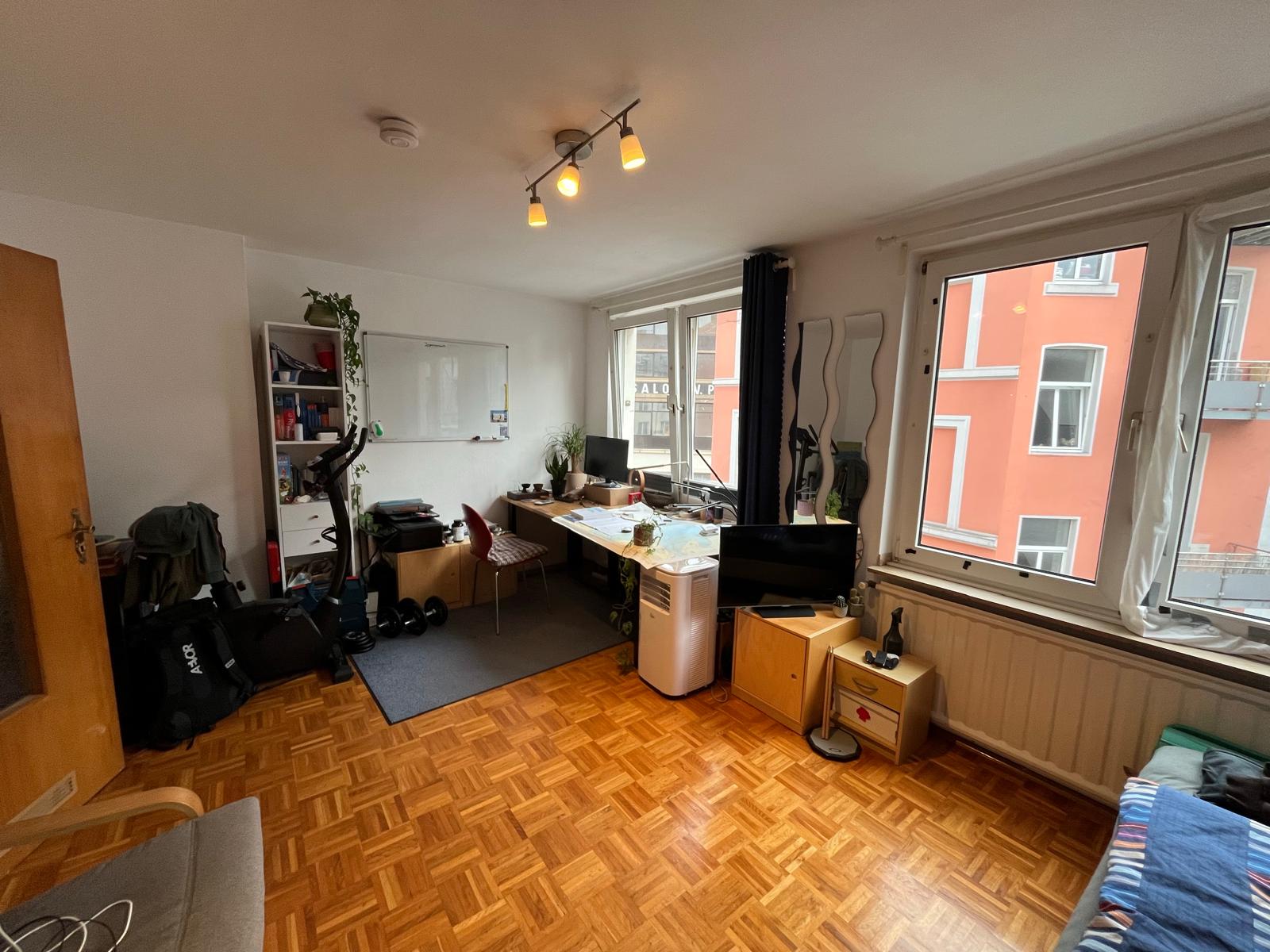 Heller Wohnraum mit Eichenparkett und großen Fenstern in der Wohnung in Aachen