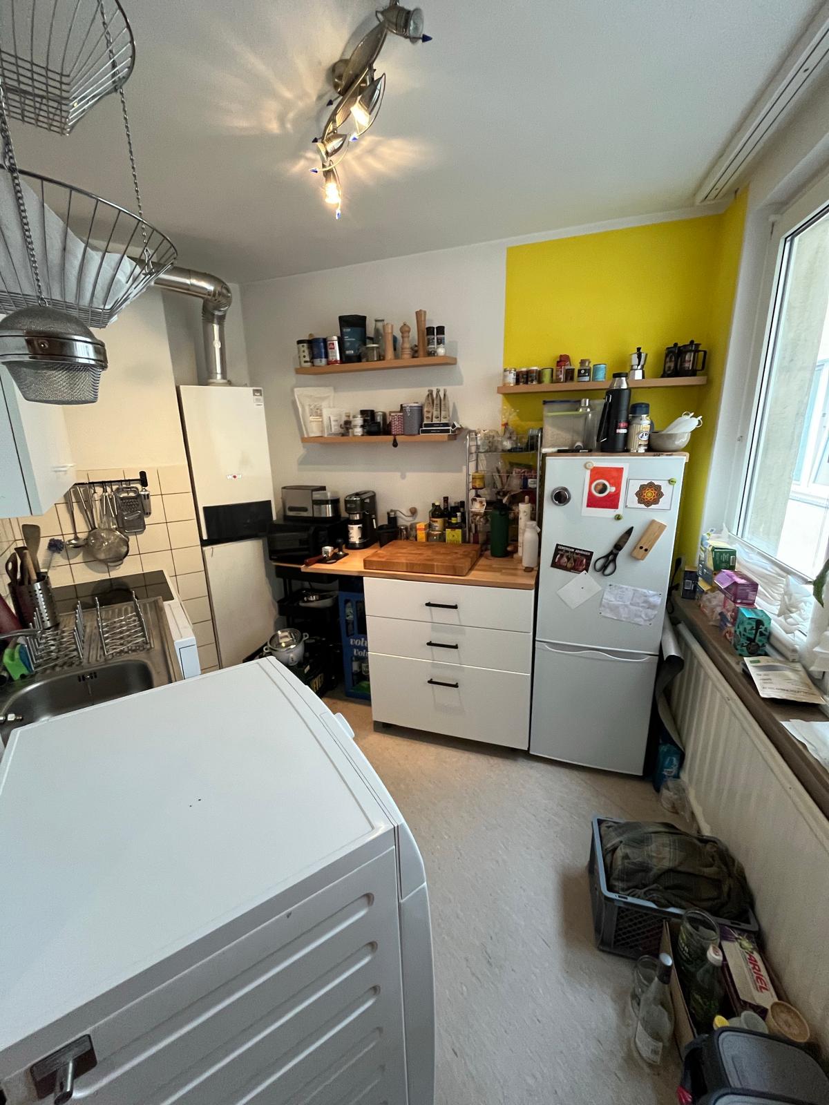 Küche mit Kühlschrank und gelber Wand in der Wohnung in Aachen