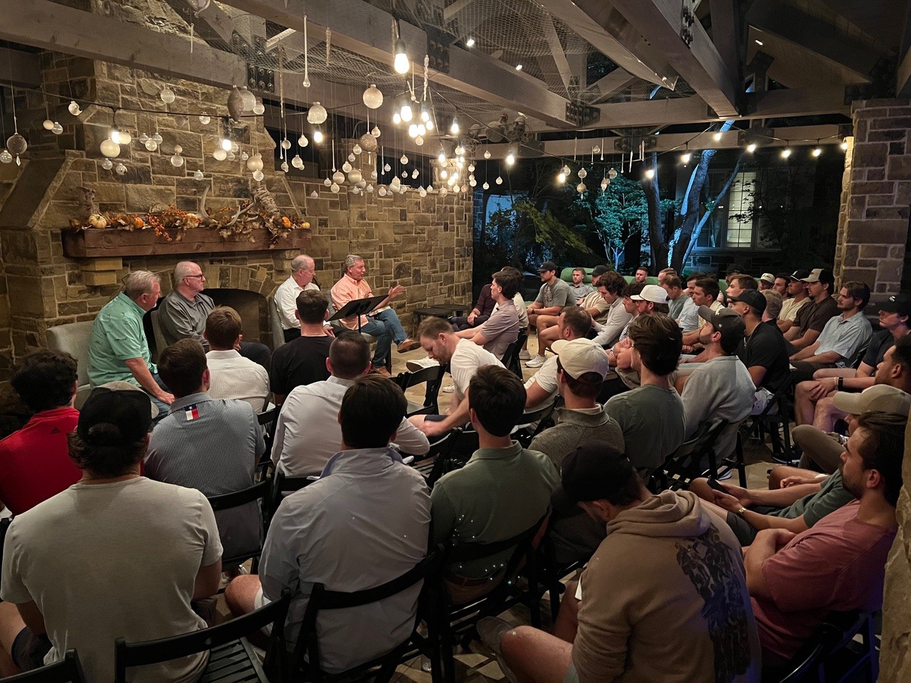 Bible study of young adult men being led by an older generation of men