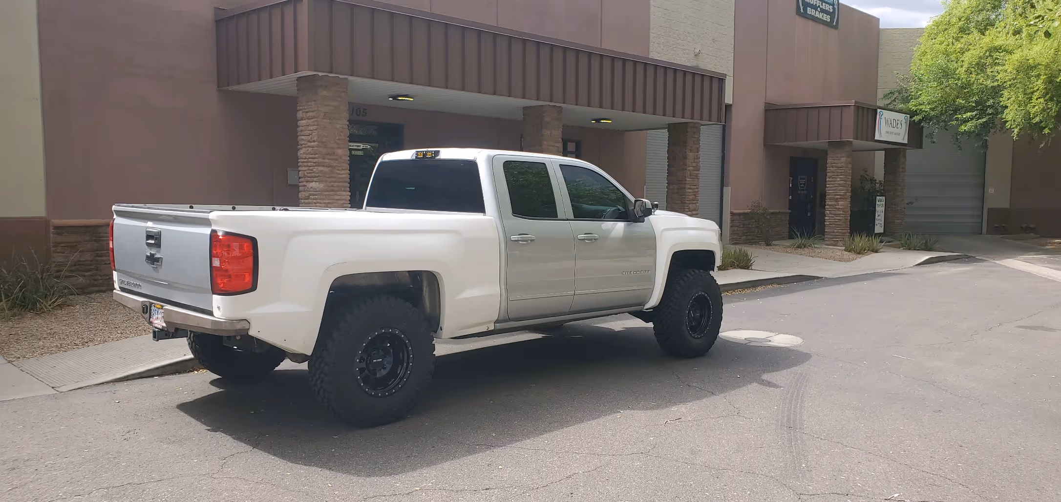 White Chevrolet pickup truck parked in front of a commercial building