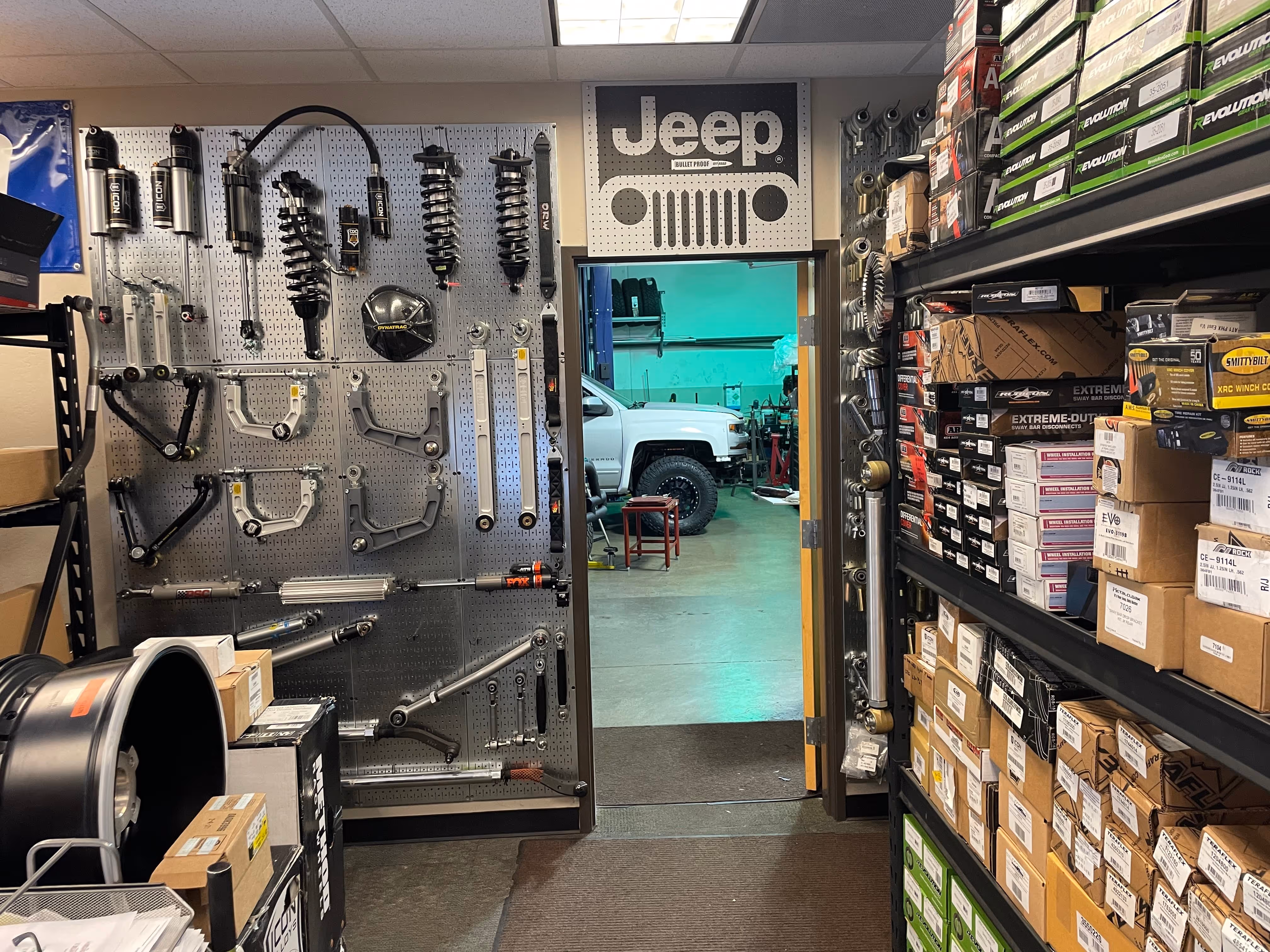 Jeep parts storage room with suspension components and shelves of automotive parts