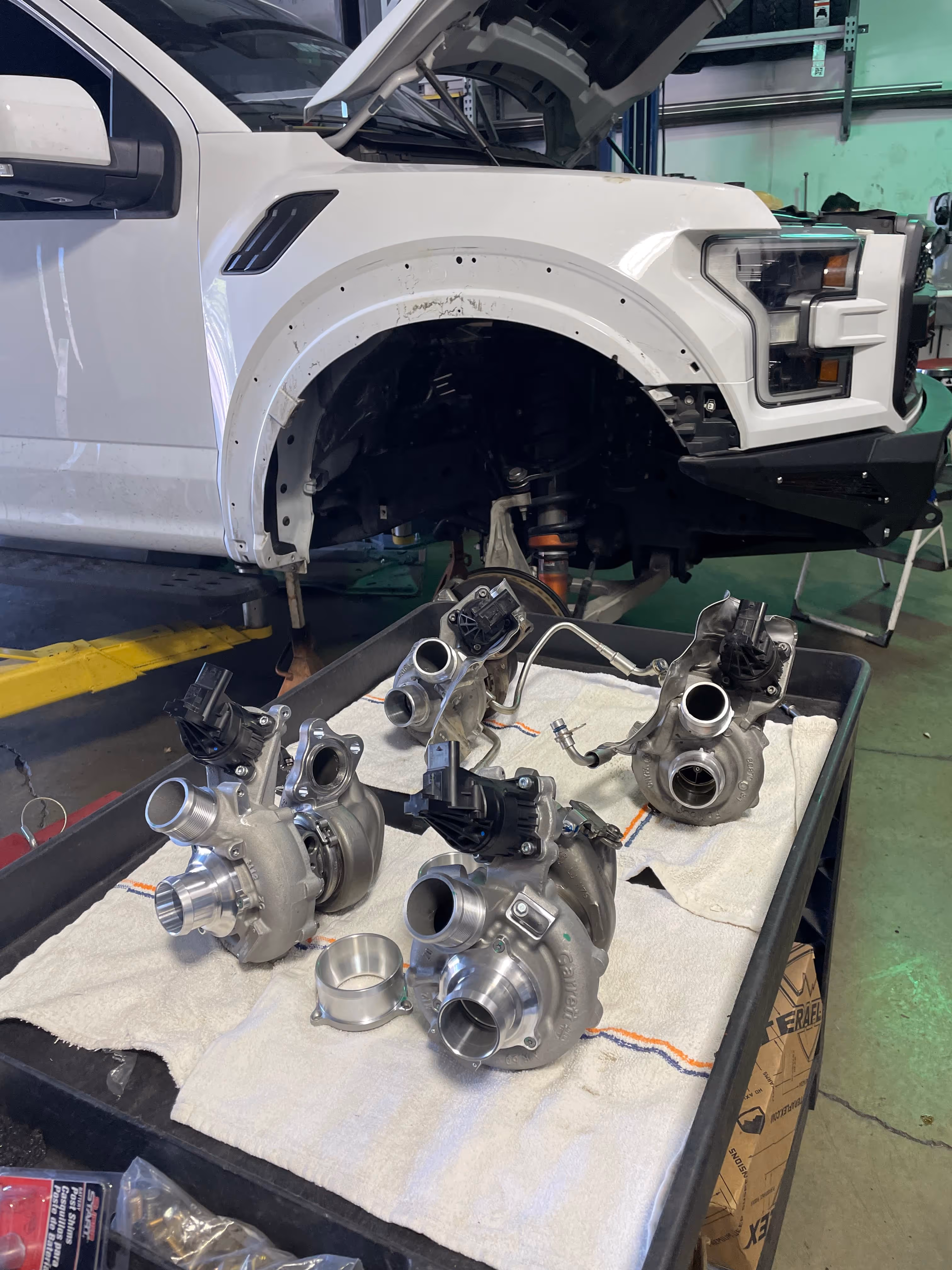 Turbochargers removed from white truck on garage workbench