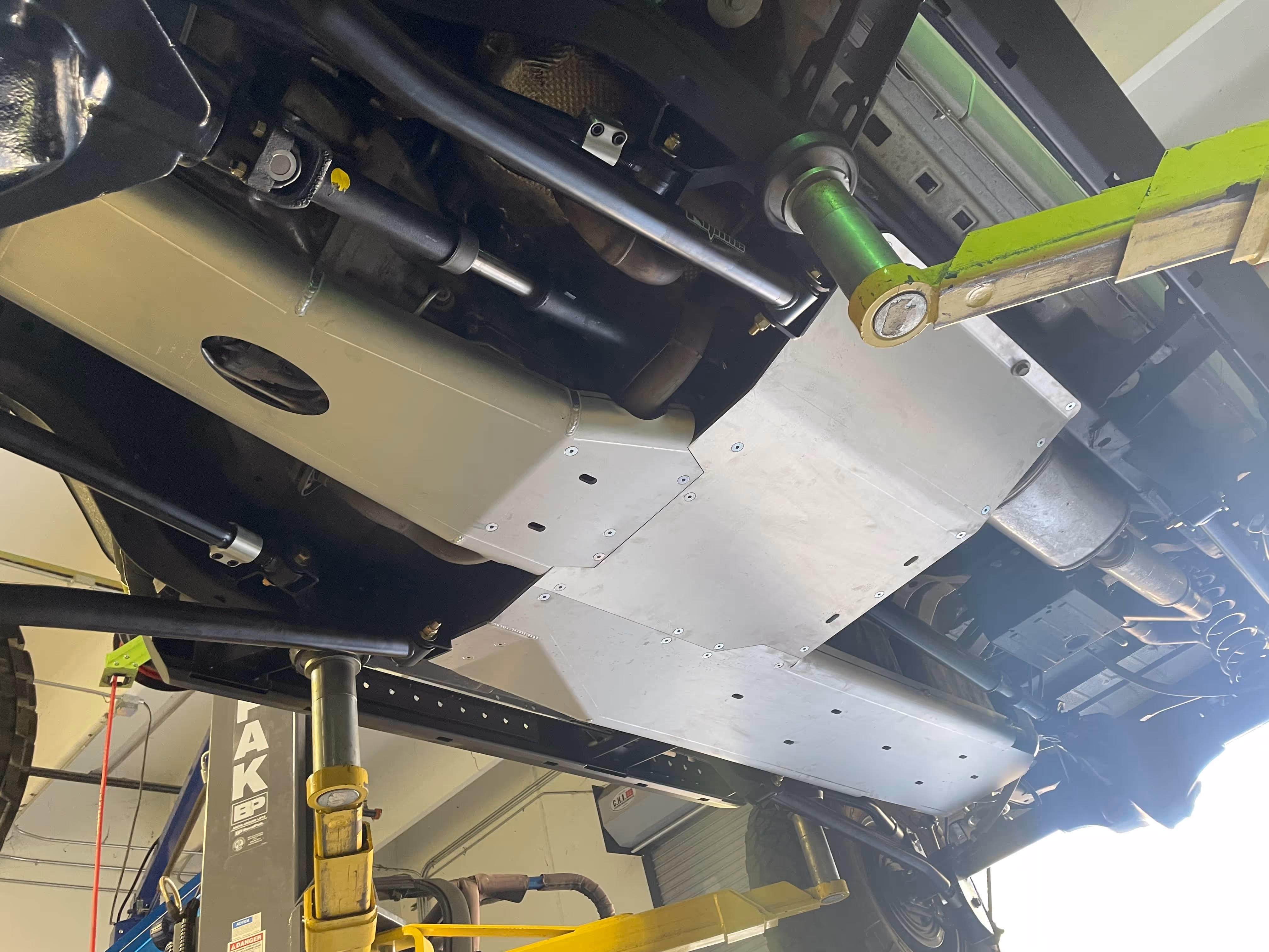 Underside of a vehicle showing mechanical components and metal panels