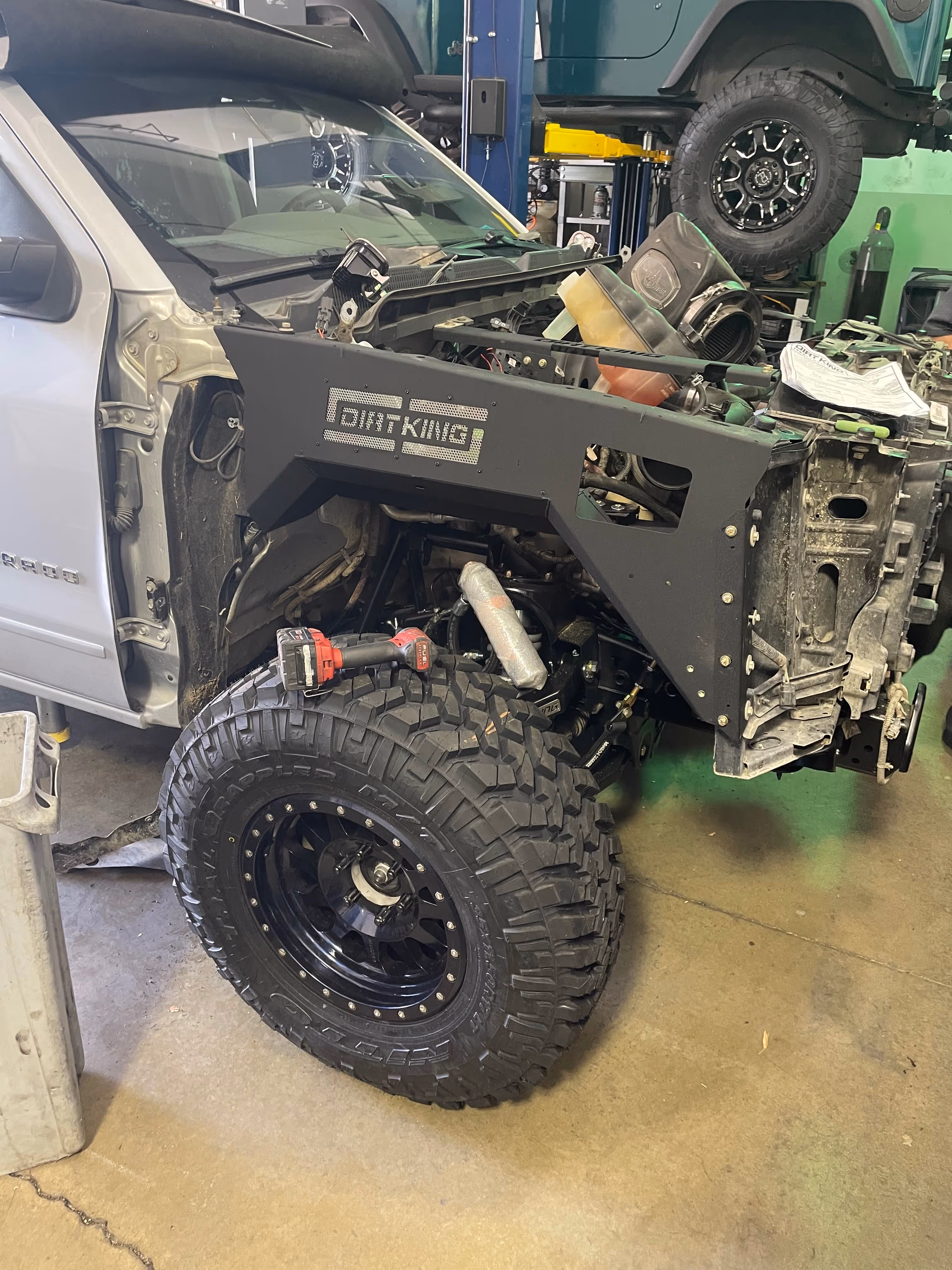 Dirt King suspension modification on off-road truck in automotive workshop