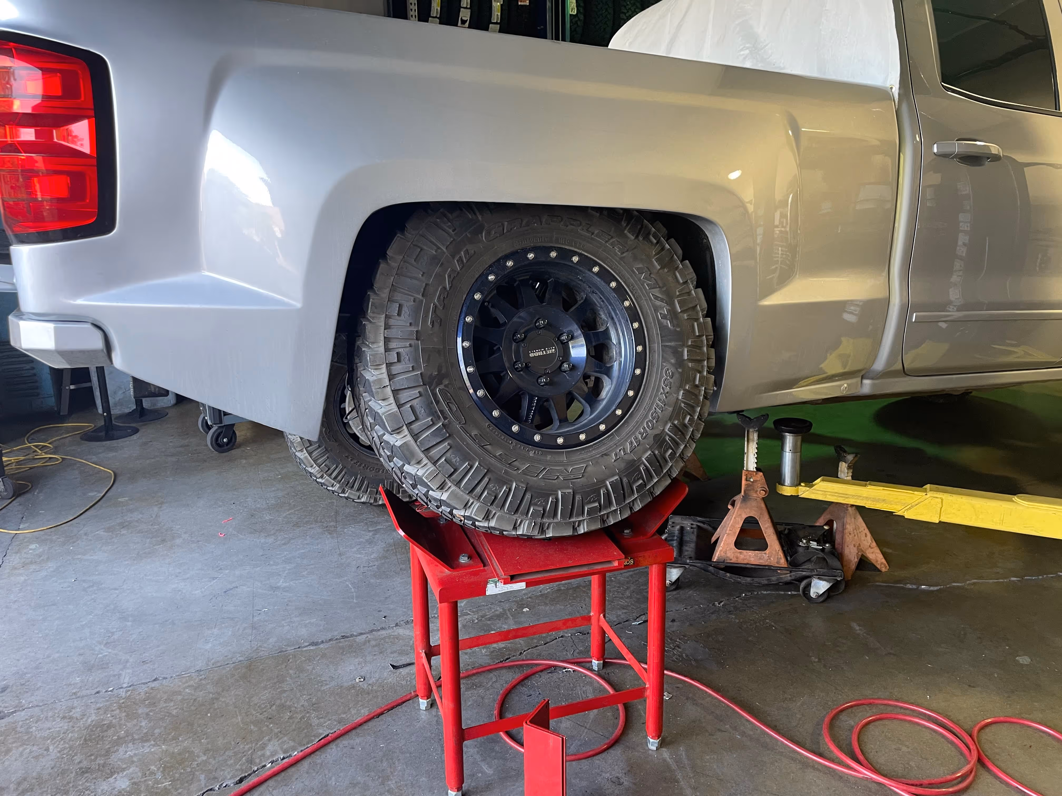 Truck tire on red stand in garage during maintenance or repair