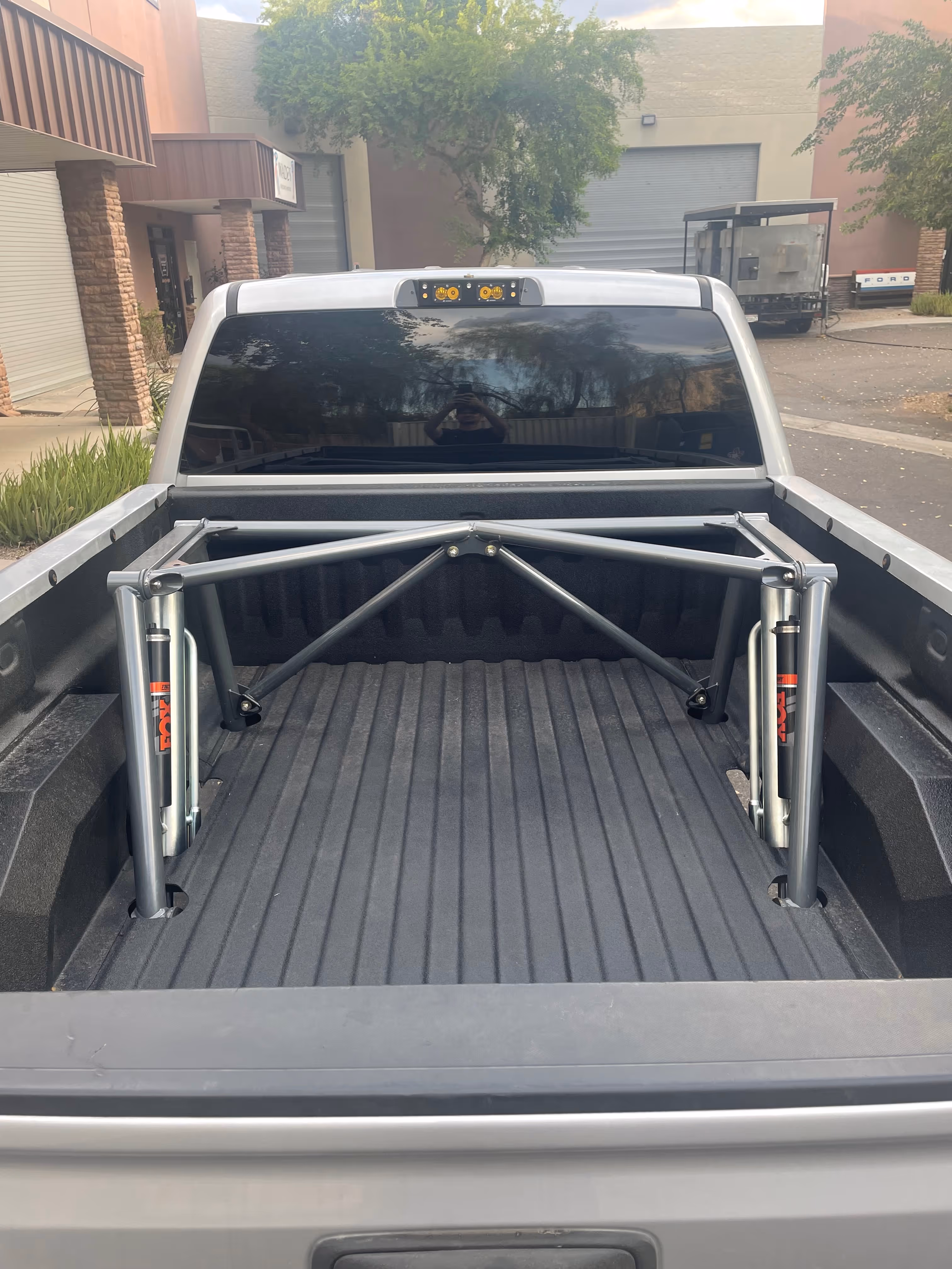Truck bed with metal support frame and adjustable hydraulic lift system