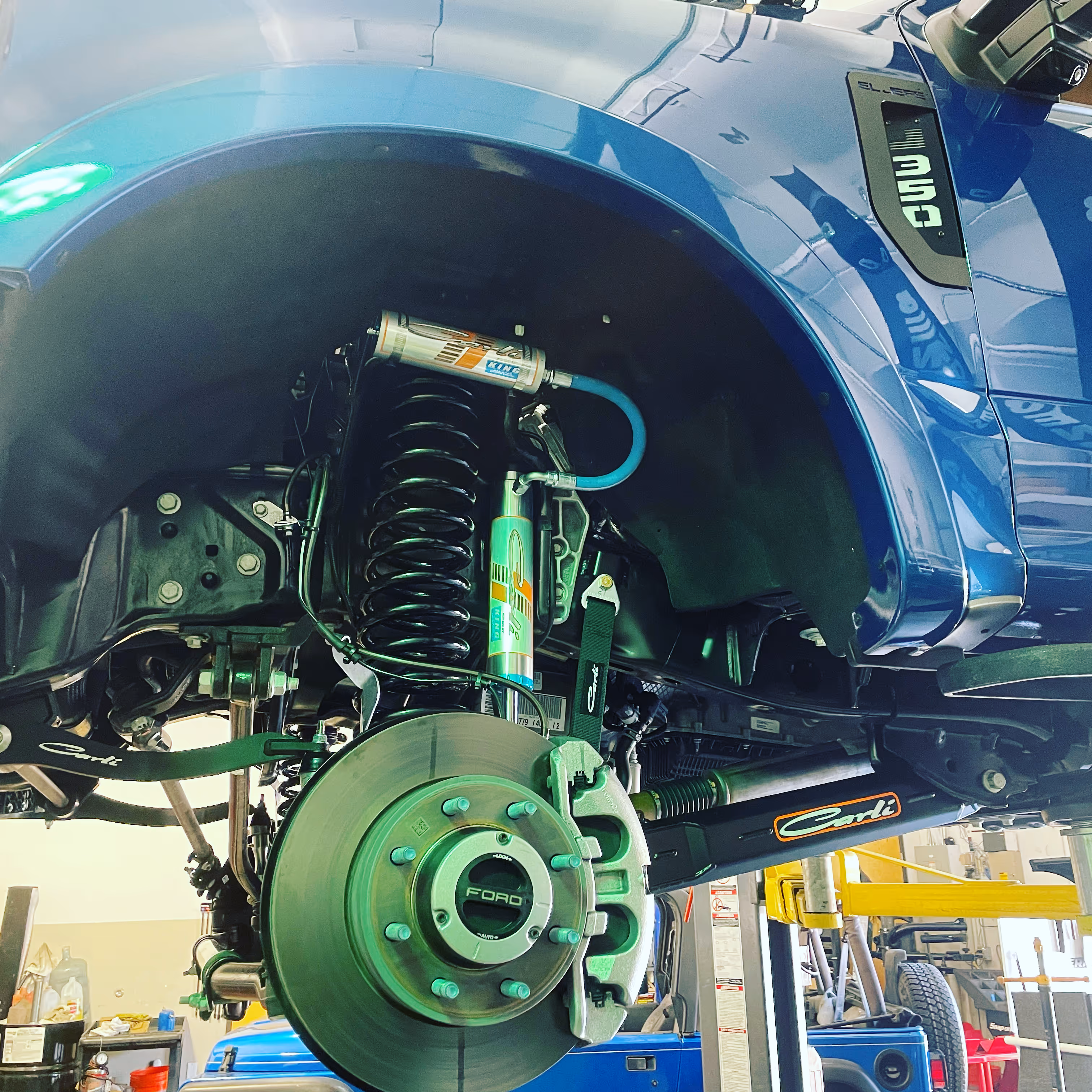 Ford vehicle suspension system with green shock absorber and brake disc