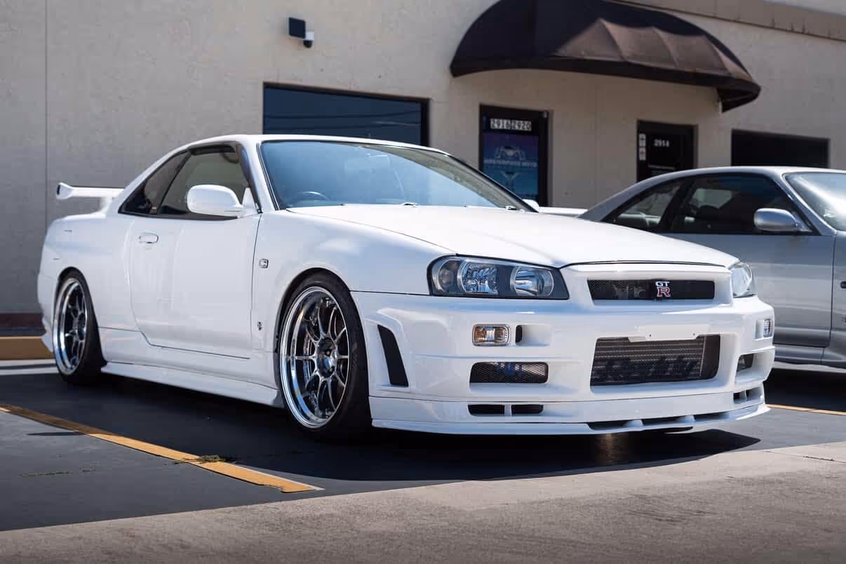 White Nissan Skyline GT-R parked in lot with aftermarket wheels