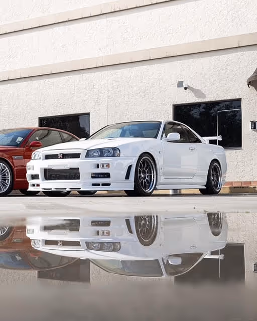 White and red Japanese sports cars reflected on wet ground