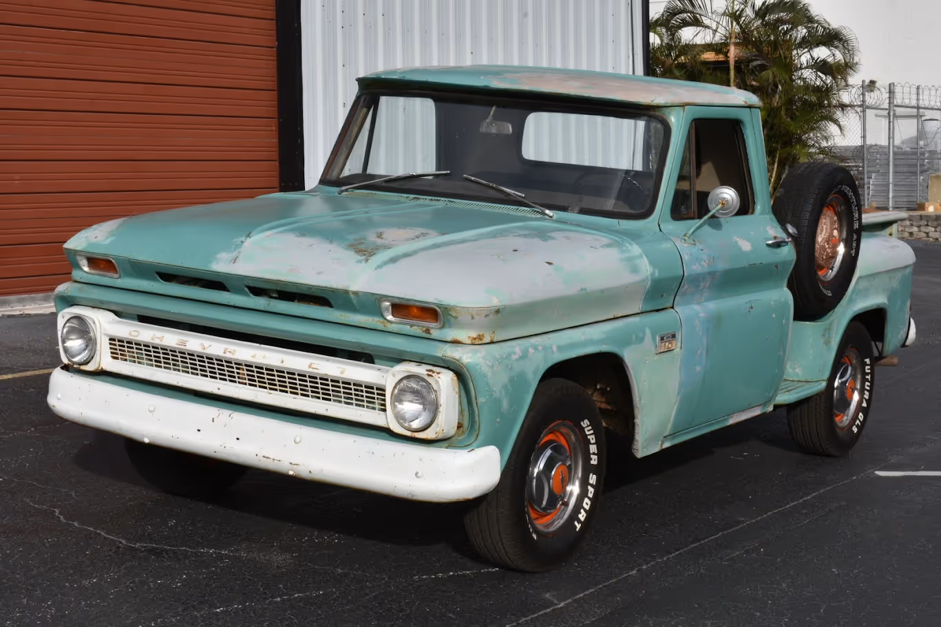 Vintage turquoise Chevrolet pickup truck with weathered paint parked outside