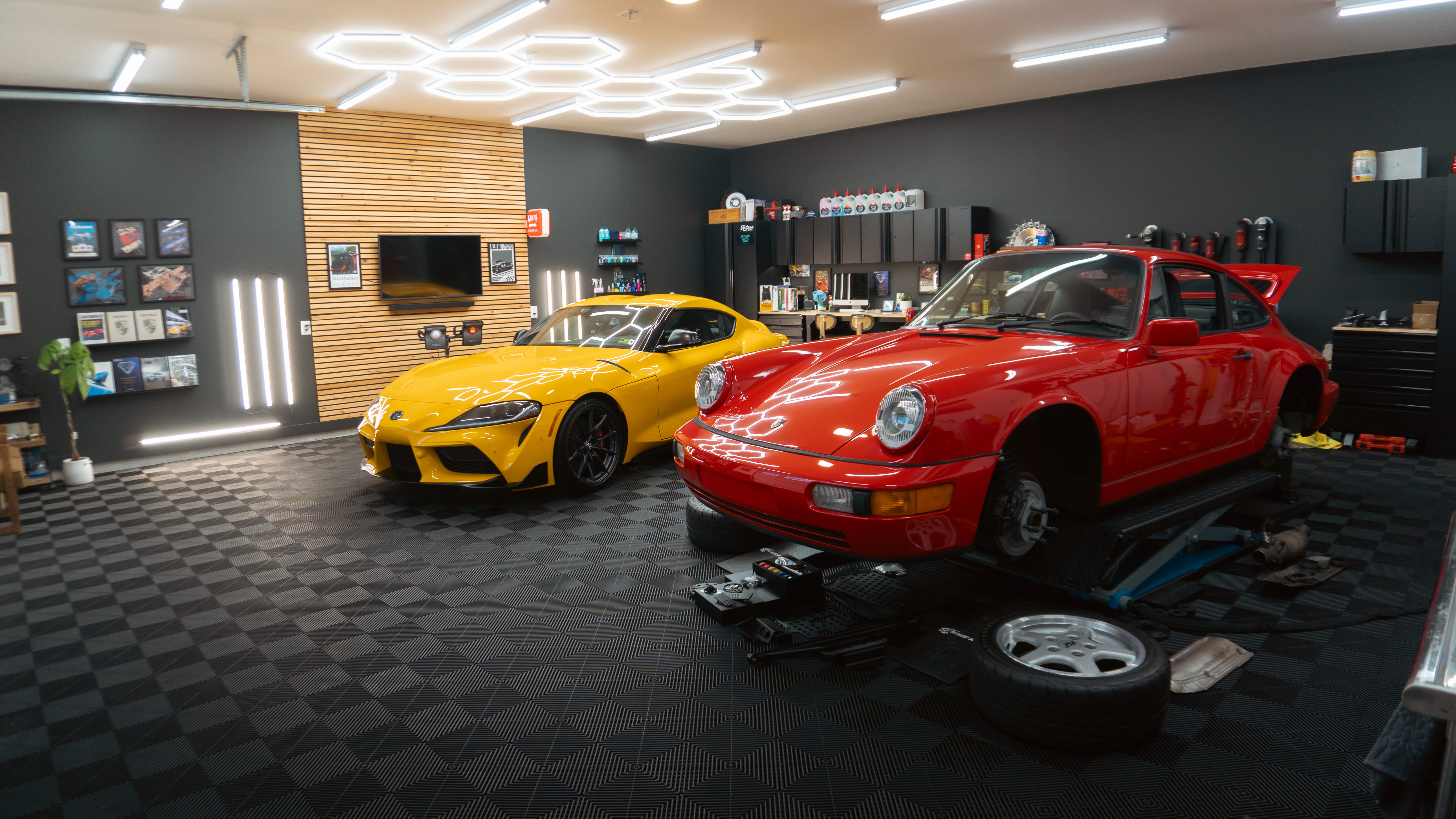 Yellow and red sports cars in a modern, well-equipped automotive workshop