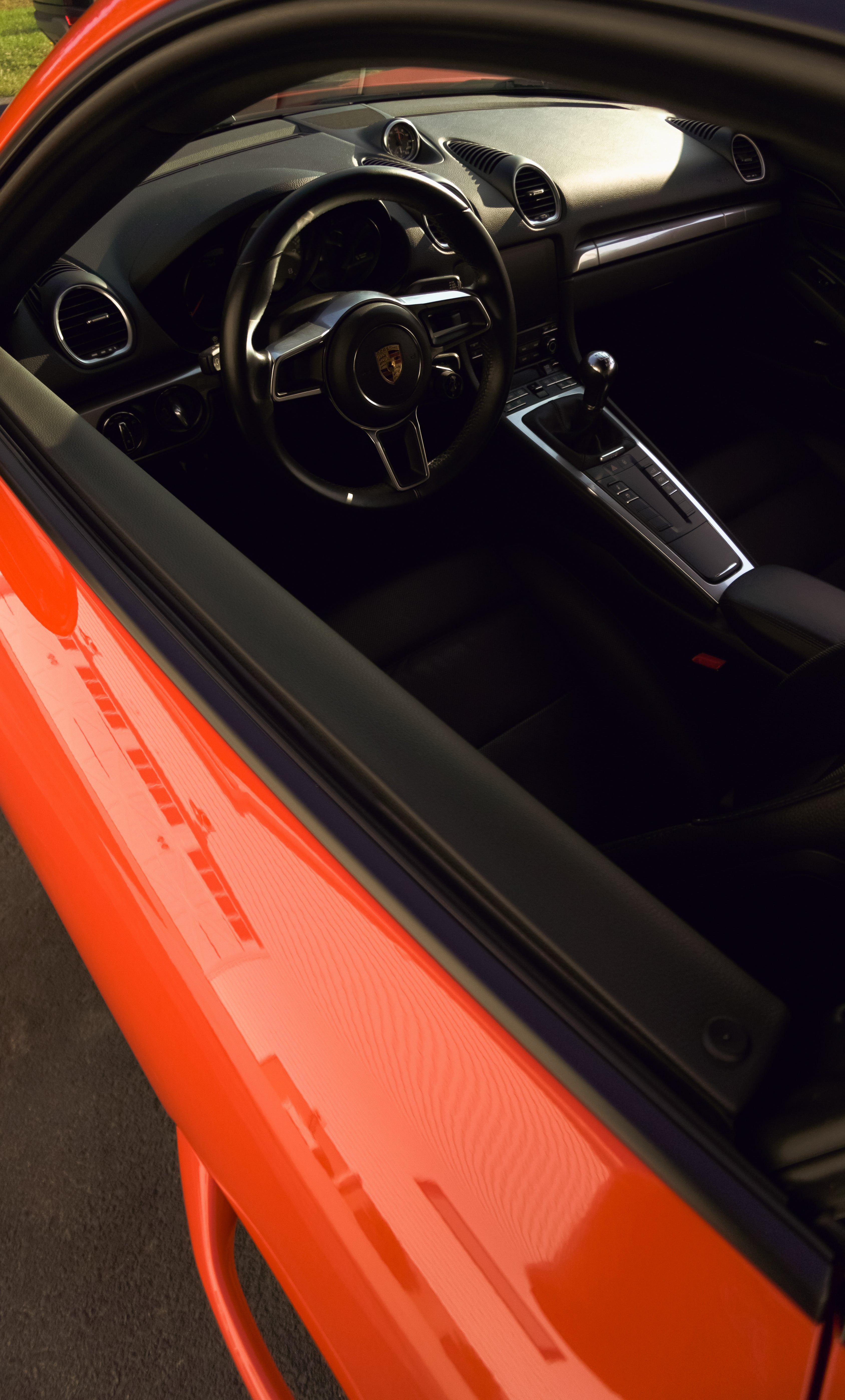 Bright orange Porsche interior with sleek black dashboard and steering wheel