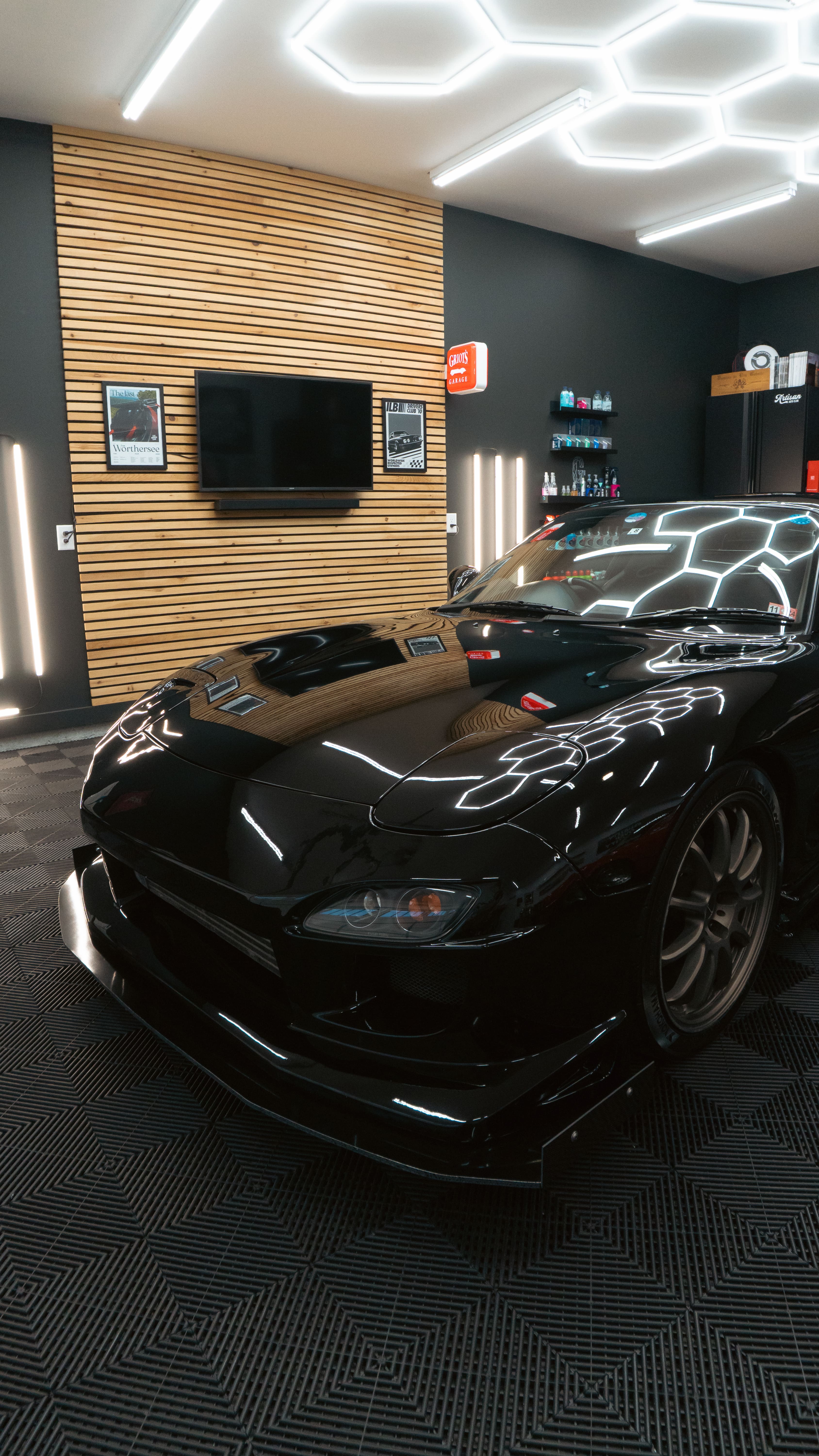 Black sports car with glowing lines parked in modern showroom interior