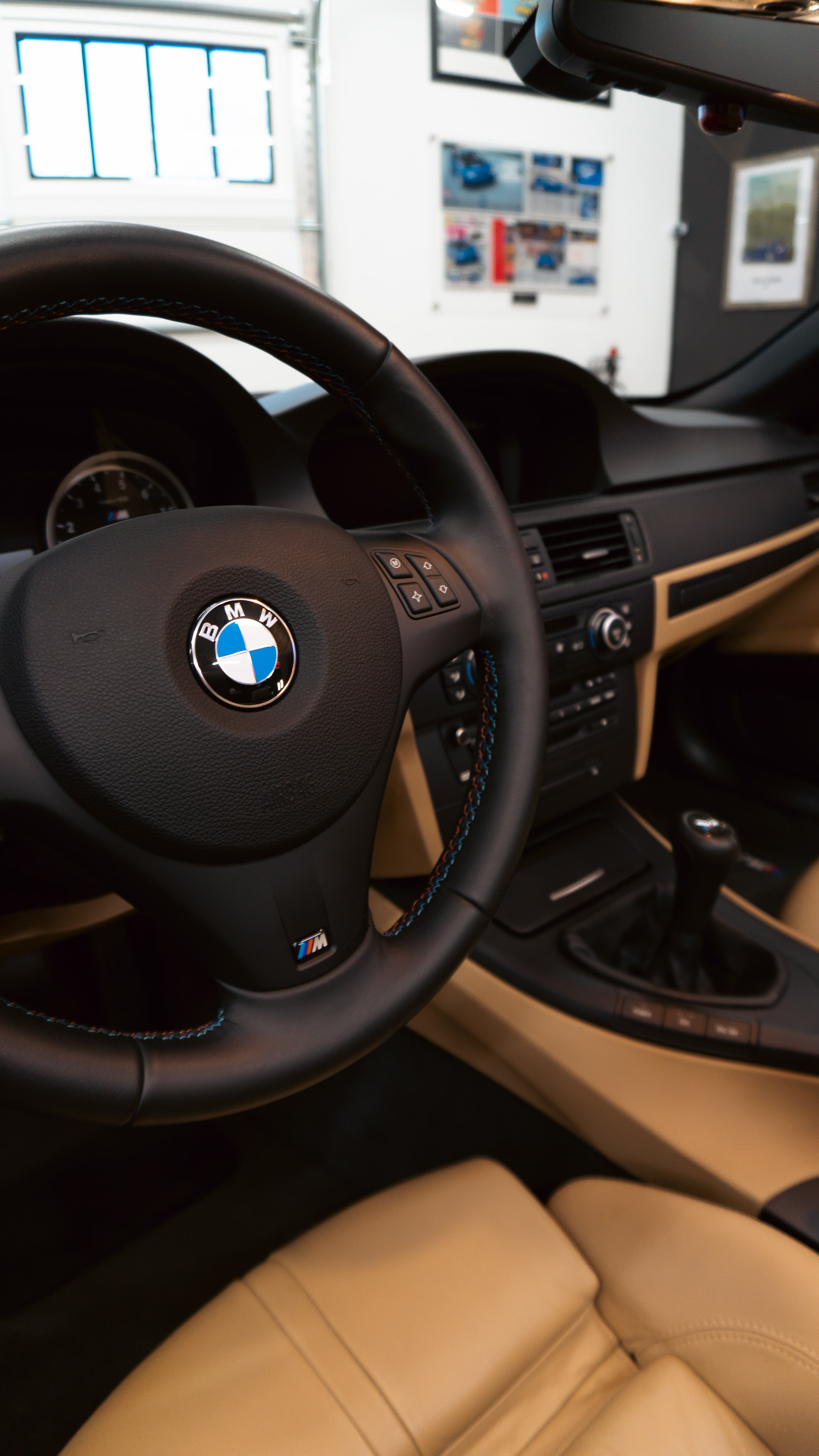 BMW interior with steering wheel and leather seats in modern showroom