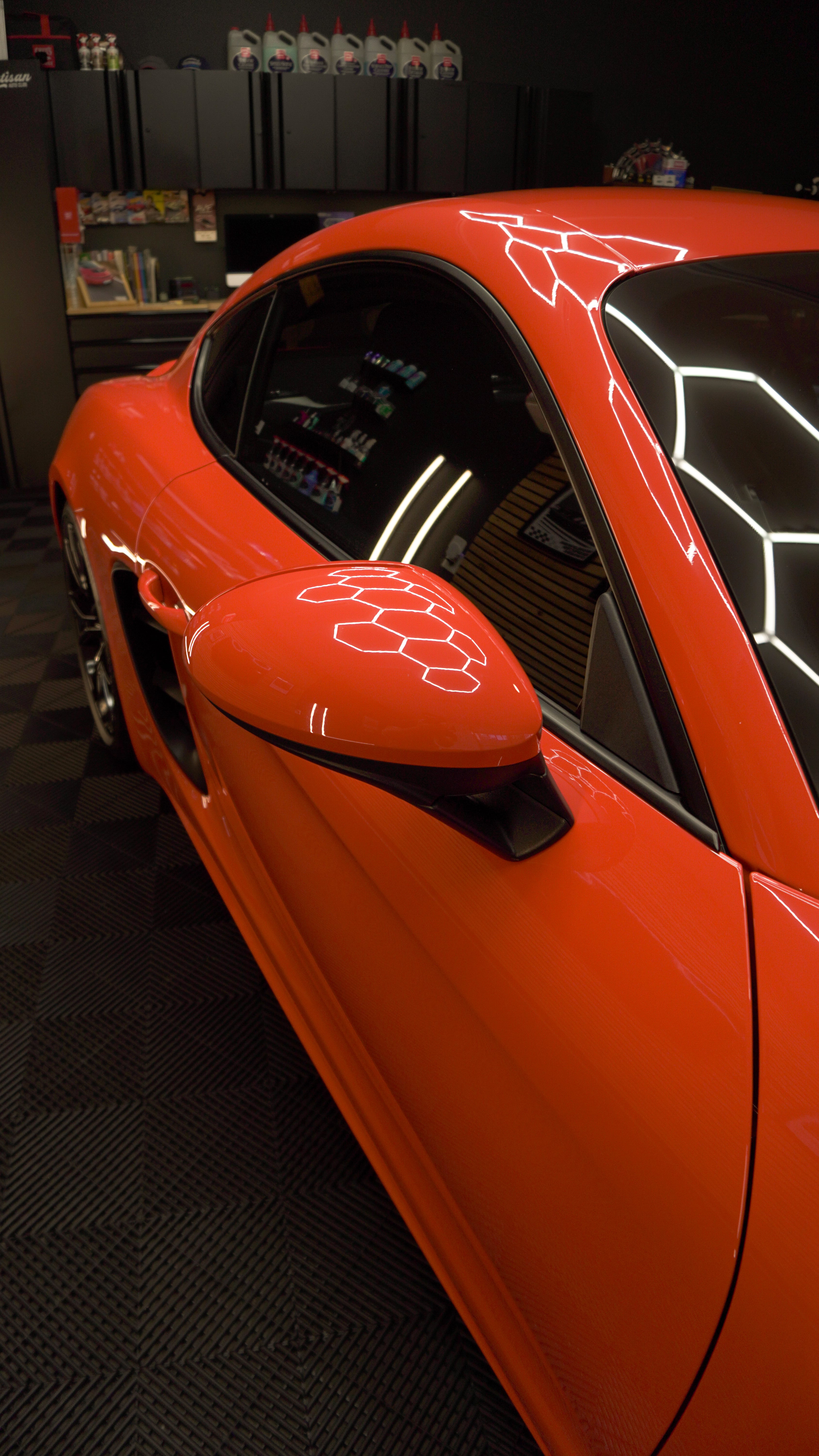 Bright red sports car with white geometric pattern on sleek body