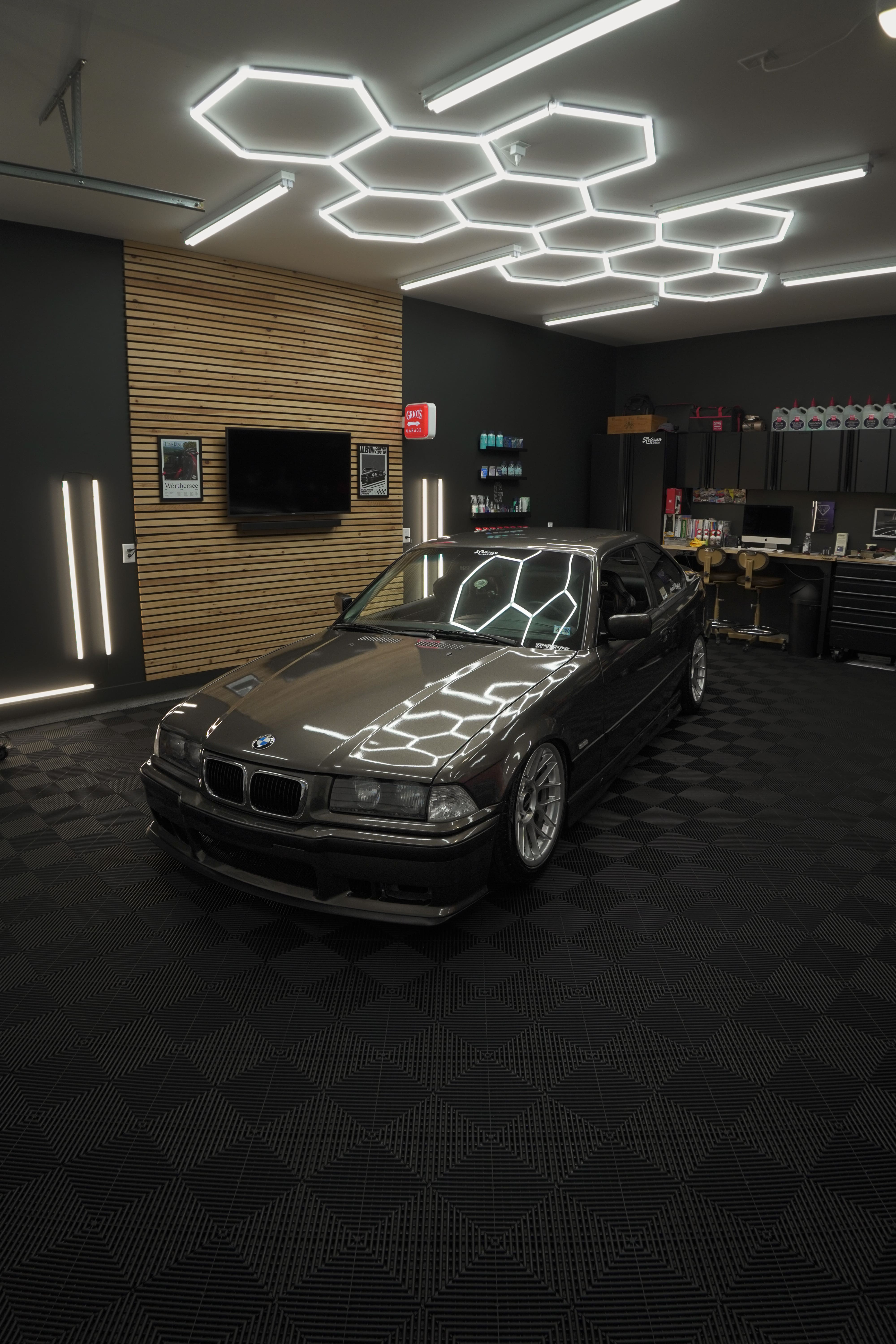Classic BMW in modern garage with hexagonal geometric lighting design