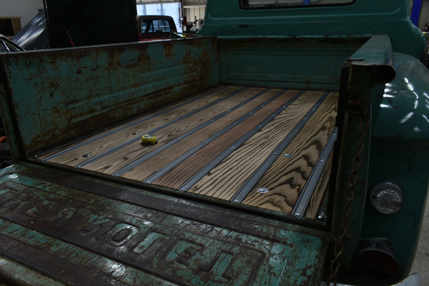 Vintage green truck bed with wooden planks and metal strips