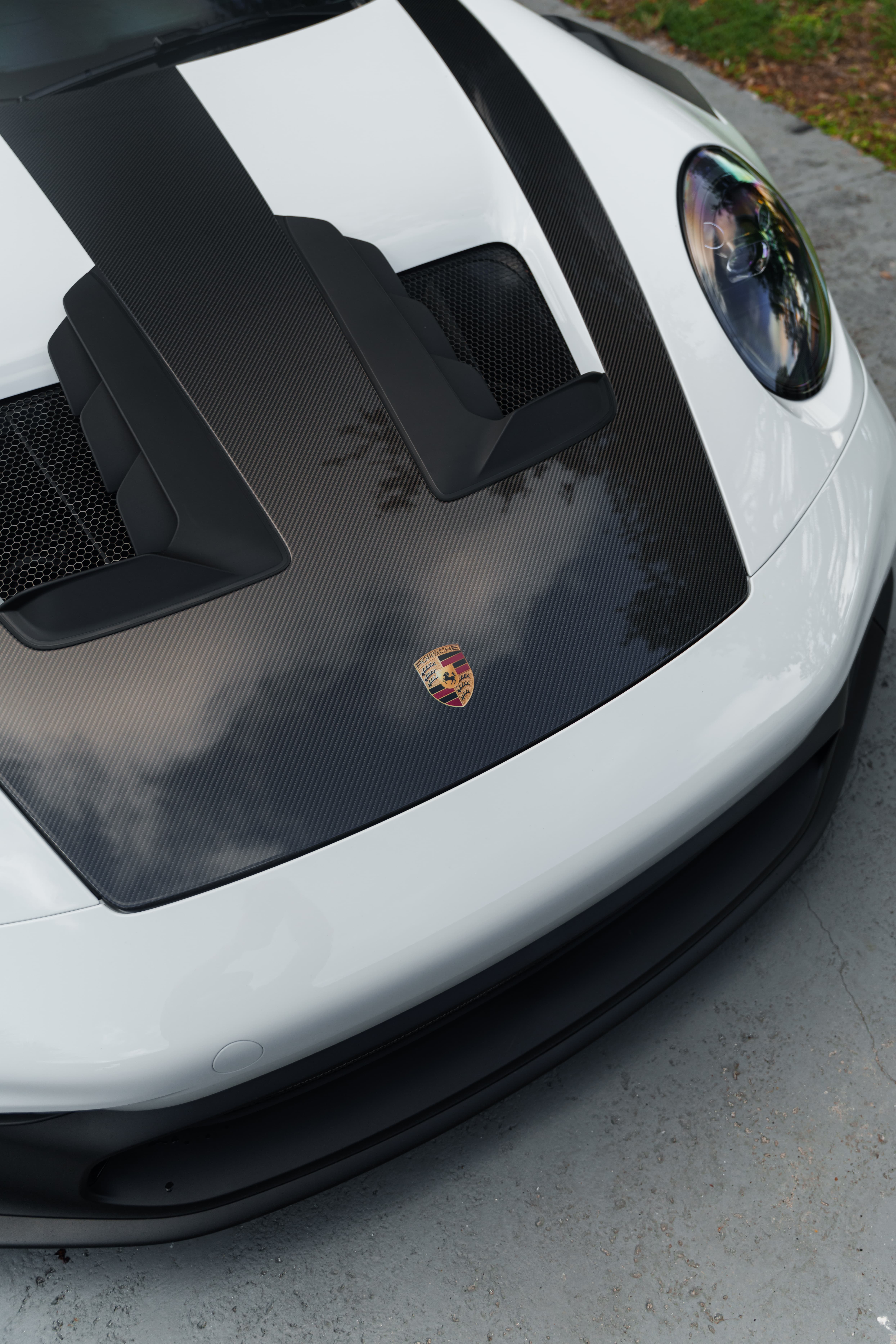 White and black Porsche sports car with carbon fiber details