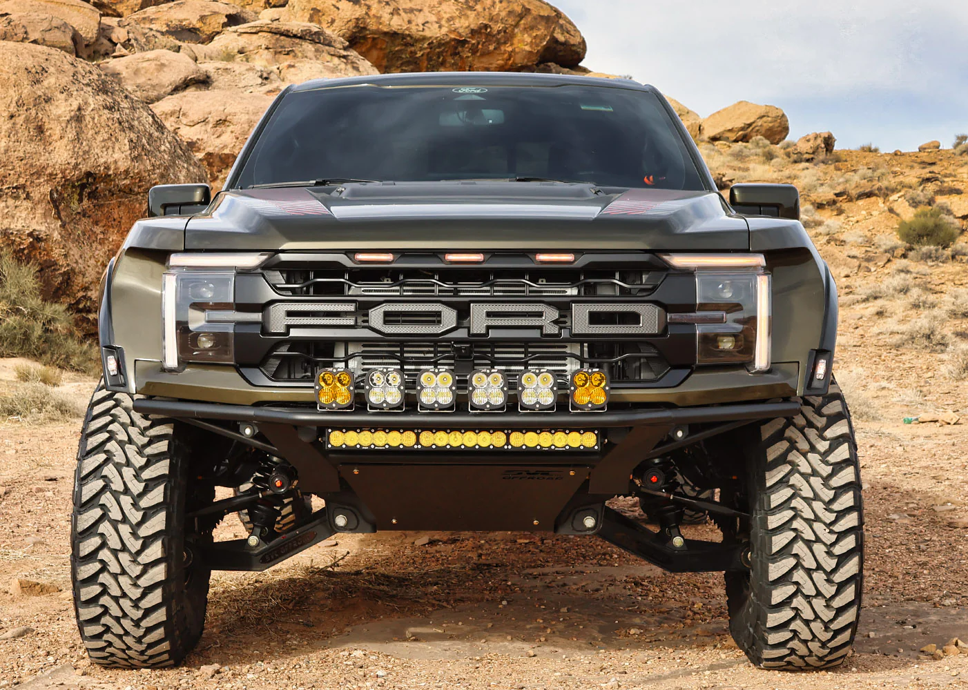 Ford truck with off-road bumper and light bar in rocky desert landscape