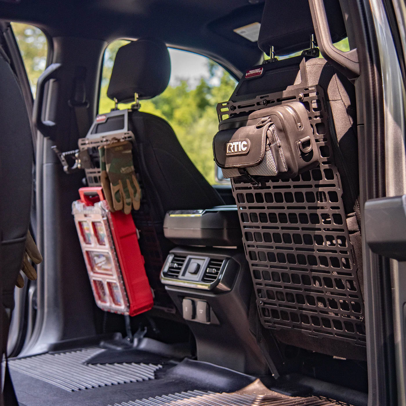 Vehicle interior with tactical molle panel, RTIC bag, and gear storage system