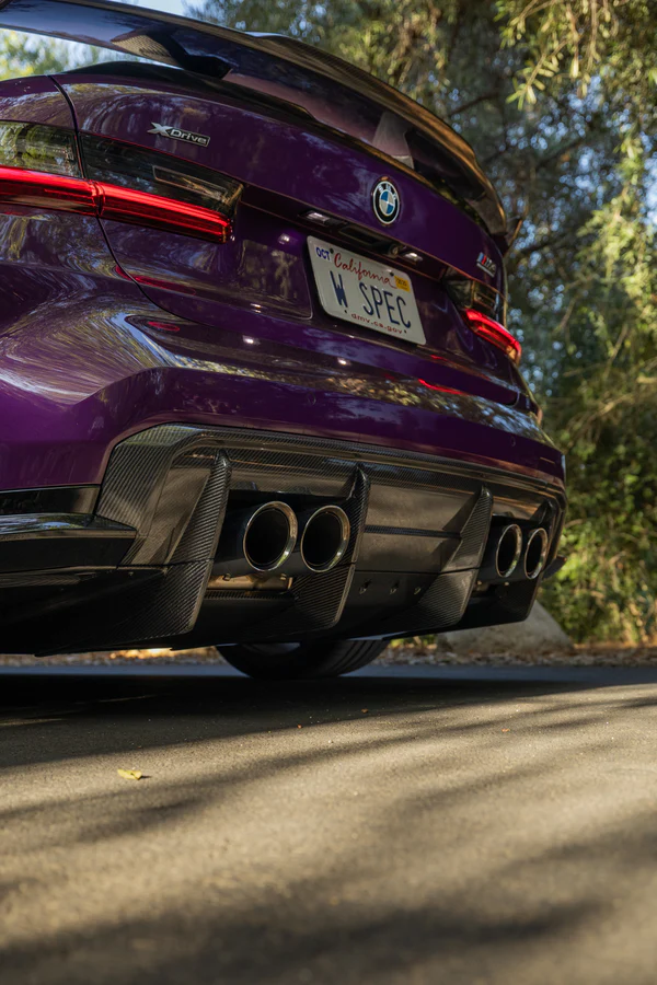 Purple BMW with carbon fiber exhaust and custom license plate parked outdoors
