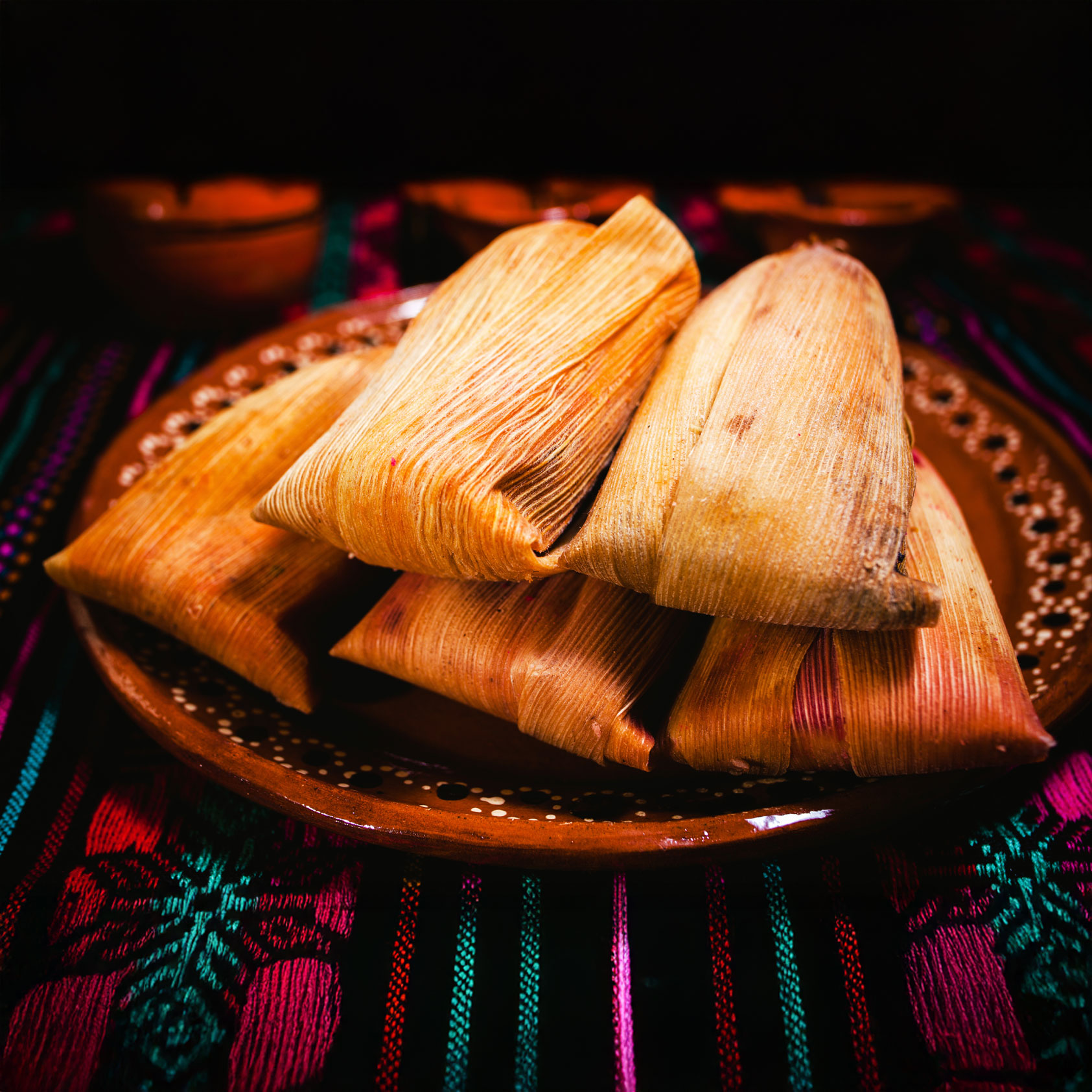 Five tamales on a plate.