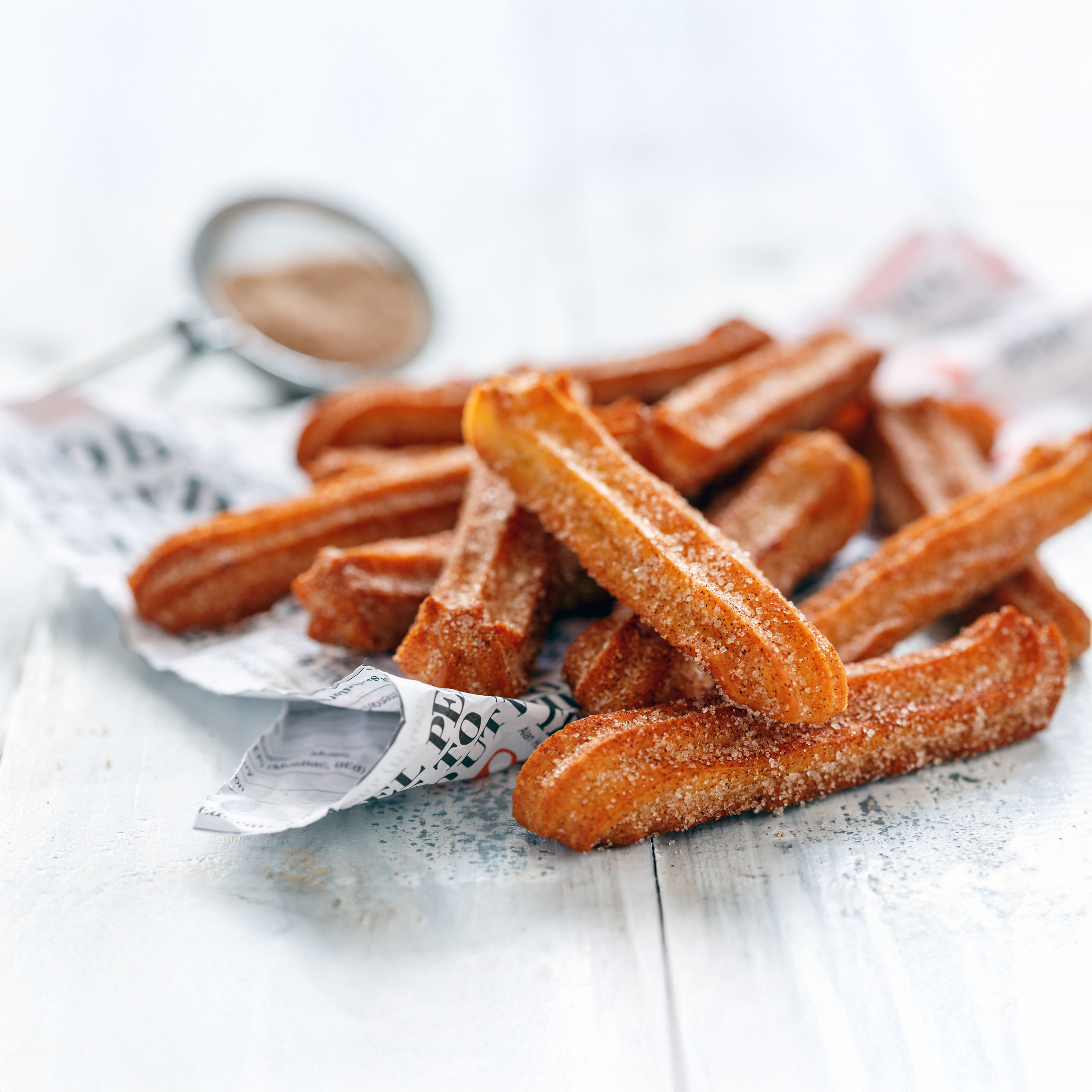 Golden-brown churros covered in sugar and cinnamon.