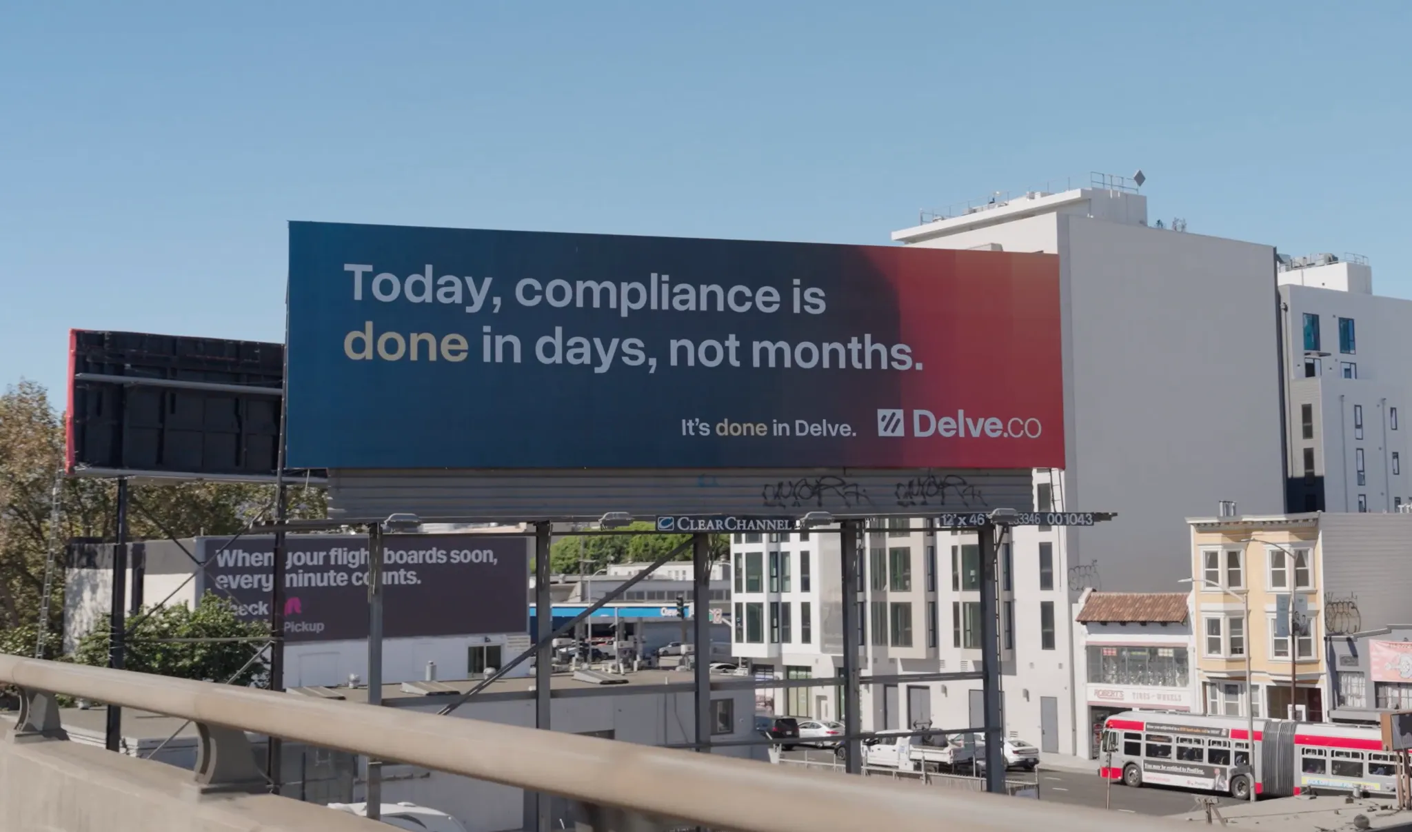 Billboard reading 'Today, compliance is done in days, not months. It's done in Delve. Delve.co' against a clear blue sky and urban backdrop.