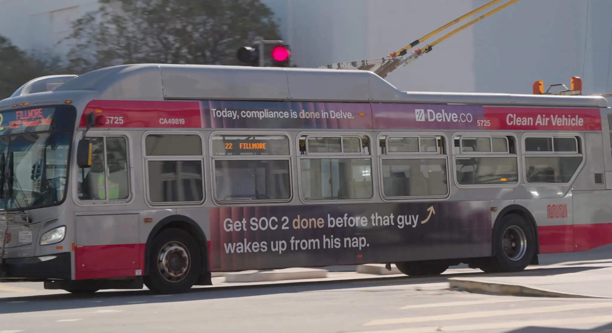 A public transit bus with advertisements for Delve.co, displaying messages about compliance and clean air vehicles.