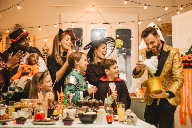 Halloween party at home Group of parents and kids having fun at Halloween party at home. A family laughing around a table covered in Halloween candy stock pictures, royalty-free photos & images