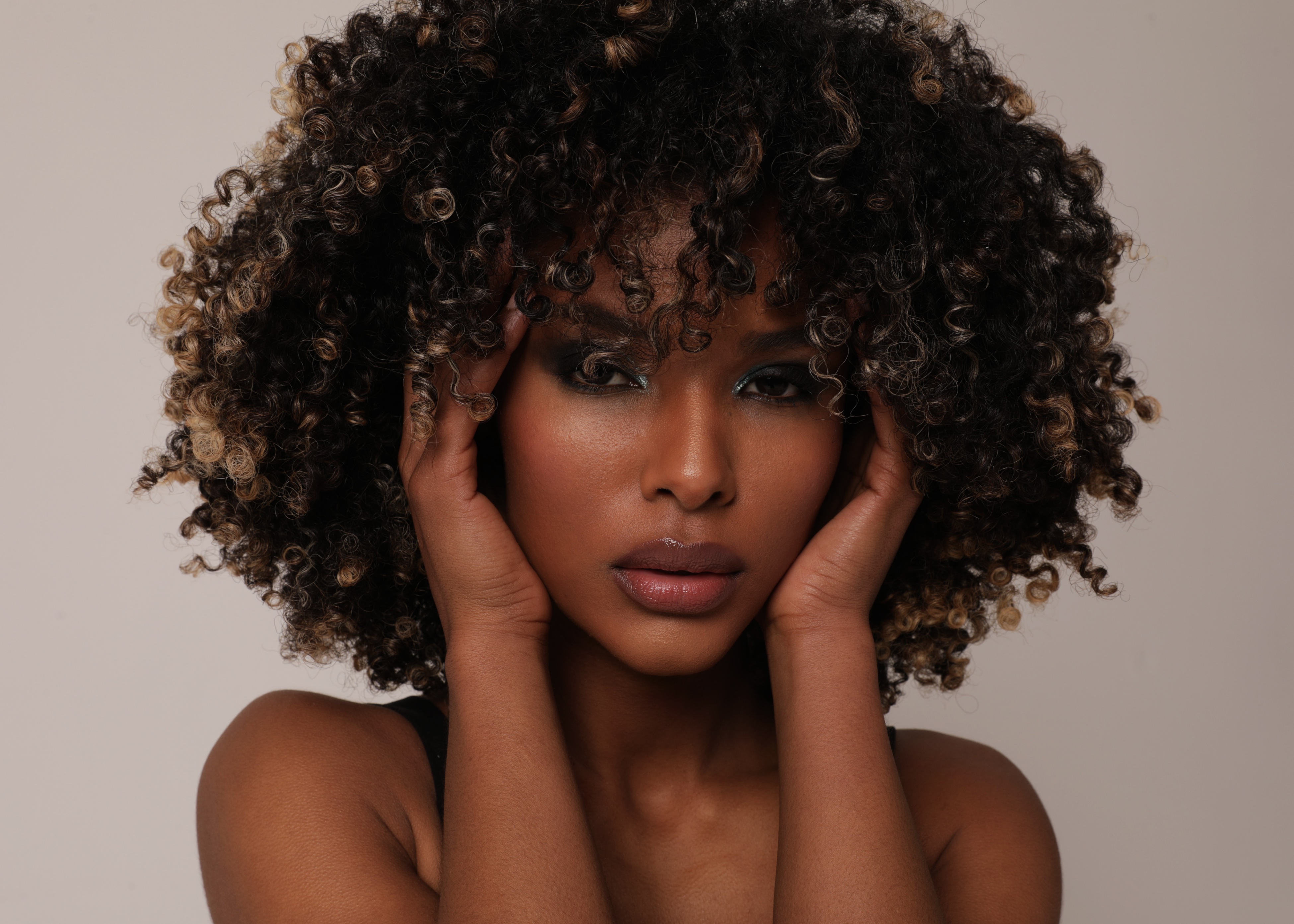 A close up of a woman with curly hair.