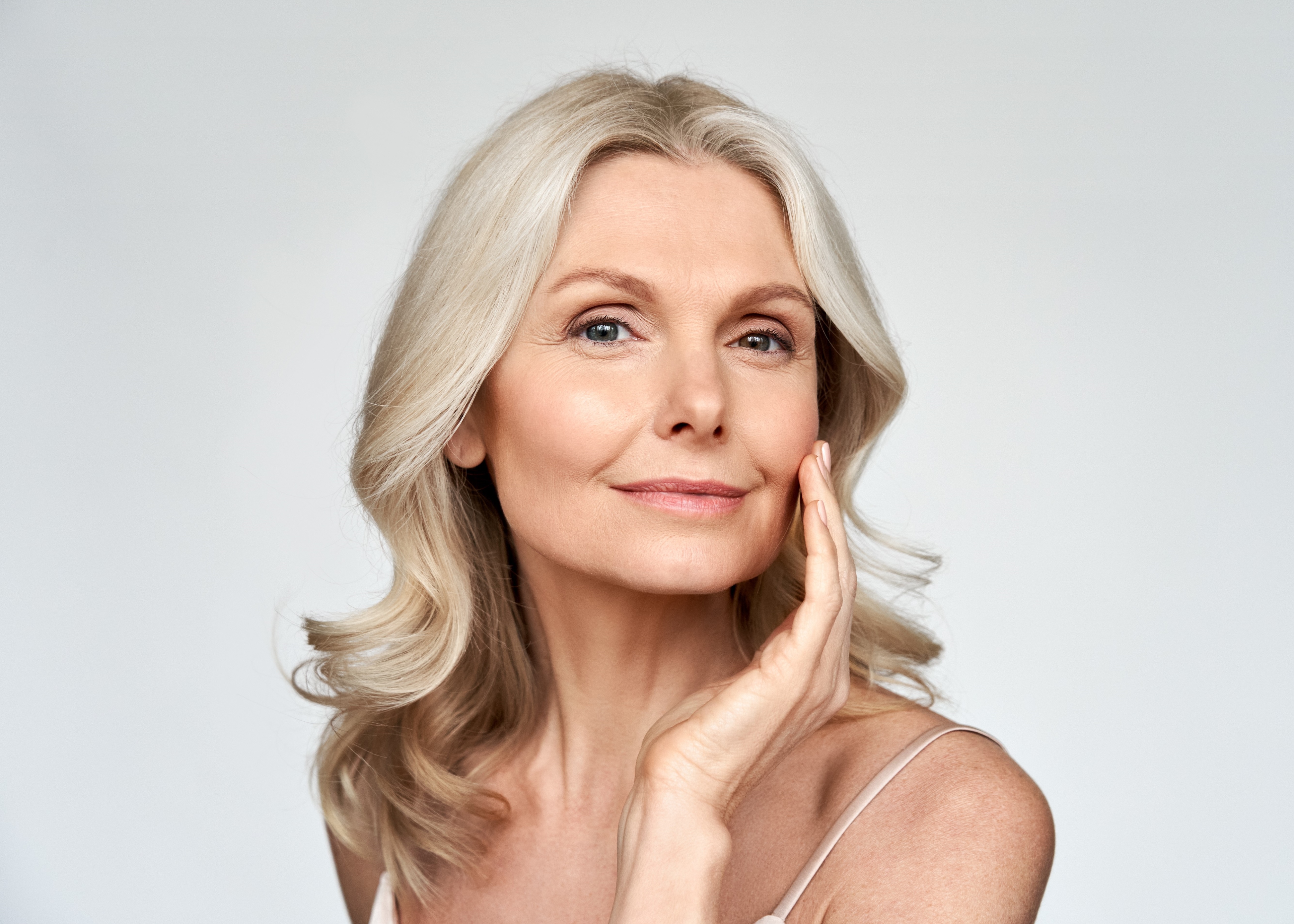 A woman posing for a picture with her hand on her face.