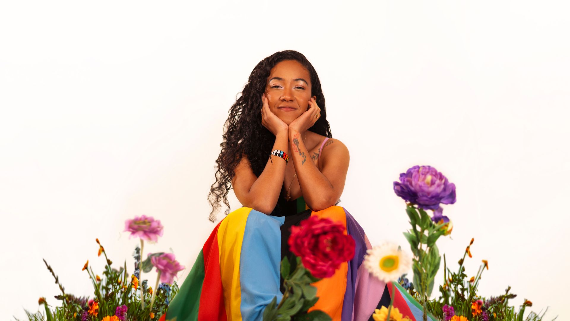 Retrato artístico de la cantautora colombiana Sara Aldana, envuelta en una atmósfera vibrante de colores, representando la conexión entre emociones, raíces afrocolombianas y psicología del color. La imagen evoca fuerza, sensibilidad y profundidad, alineada con el concepto del álbum “Matices”.