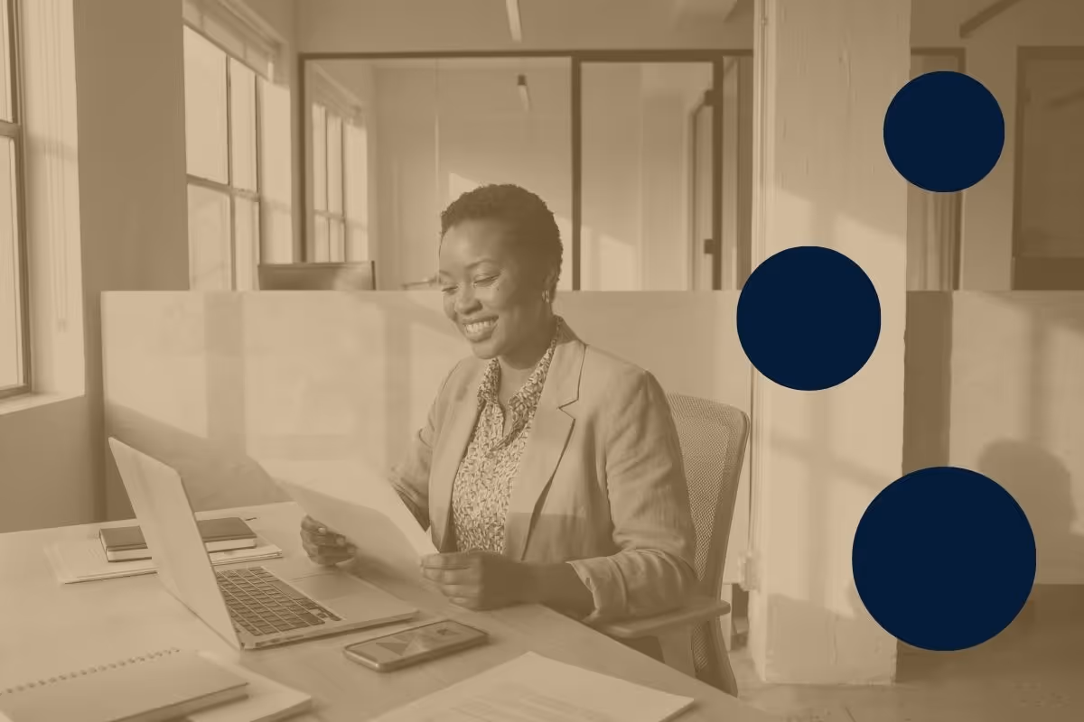 A hiring manager smiling and looking down at a piece of paper she is holding.