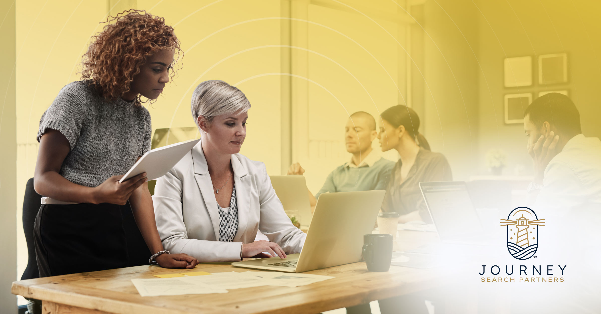 A woman working alone at a laptop in an empty, dimly lit office at night, representing HR teams asked to do more with less staff support.
