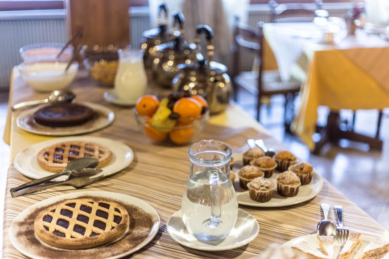 una scena mattutina che mostra crostate, dolci e bevande per la colazione dell'hotel