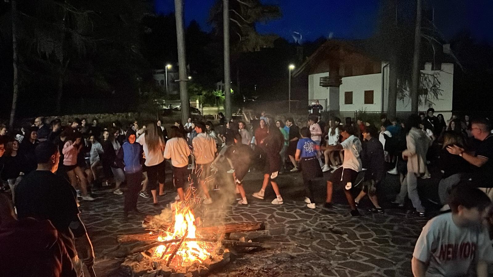 un gruppo di ragazzi che fa una festa intorno a un falò