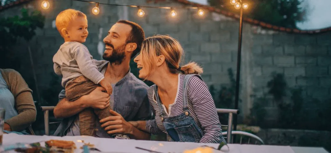 Young couple smiling at their child