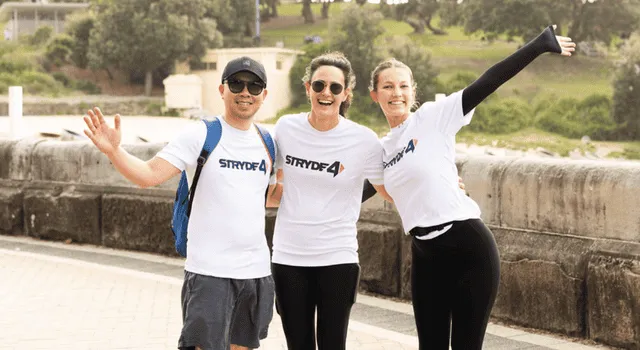 Qudos Bank staff walking for charity and smiling at the camera