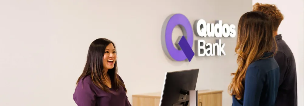 Qudos Bank staff member talking to customers in branch