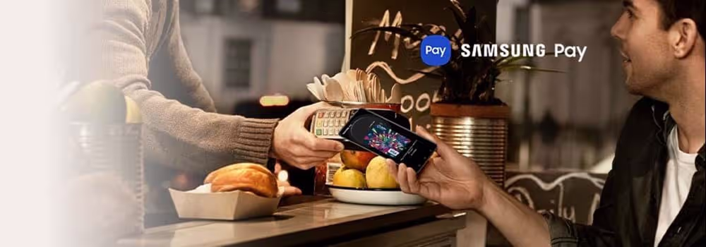 A person holding their Samsung phone to an eftopos machine to pay using Samsung Pay