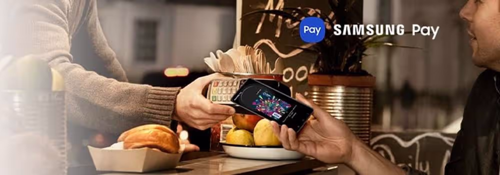 A person holding their Samsung phone to an eftopos machine to pay using Samsung Pay