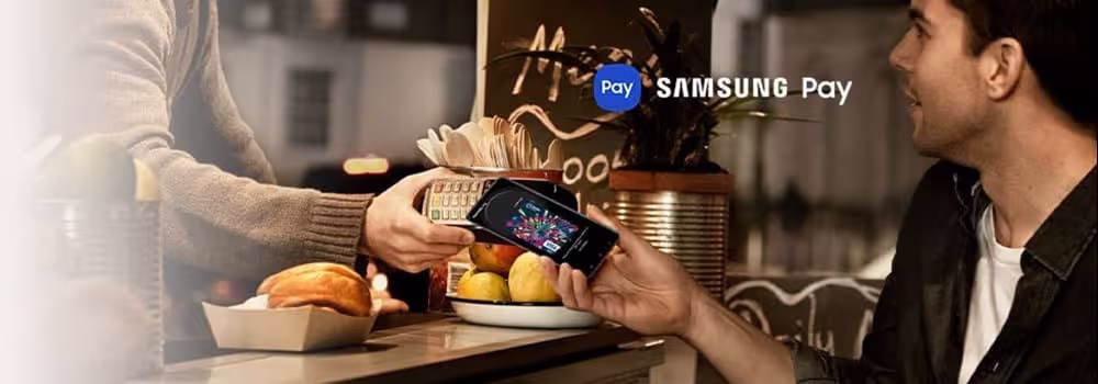 A person holding their Samsung phone to an eftopos machine to pay using Samsung Pay