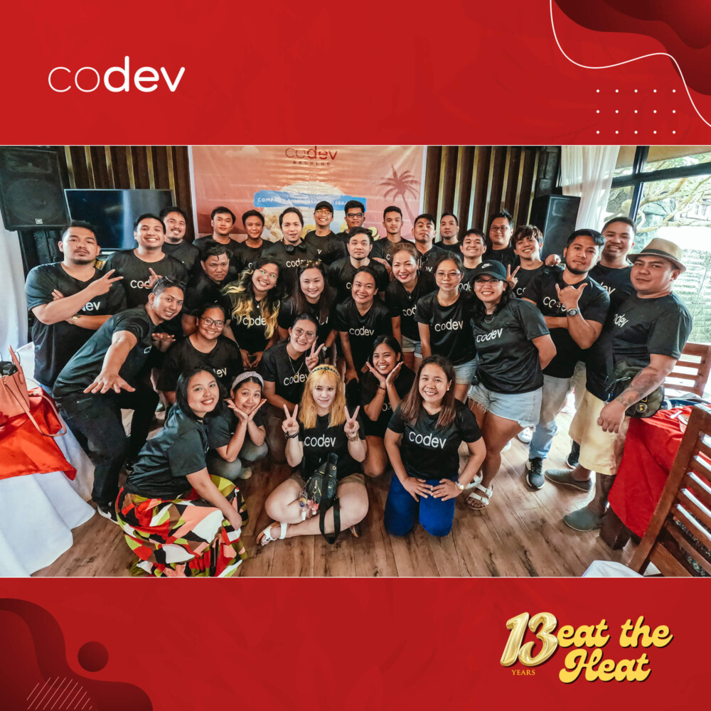 CoDev employees in Bacolod pose for an anniversary group photo indoors.