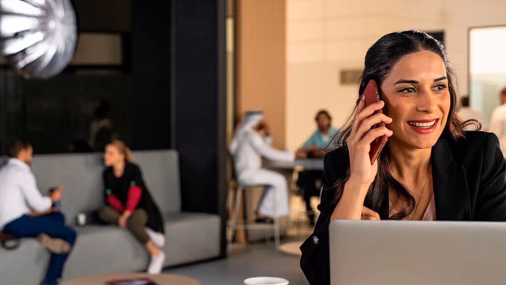 Professional woman multitasking in Dubai Knowledge Park workspace.